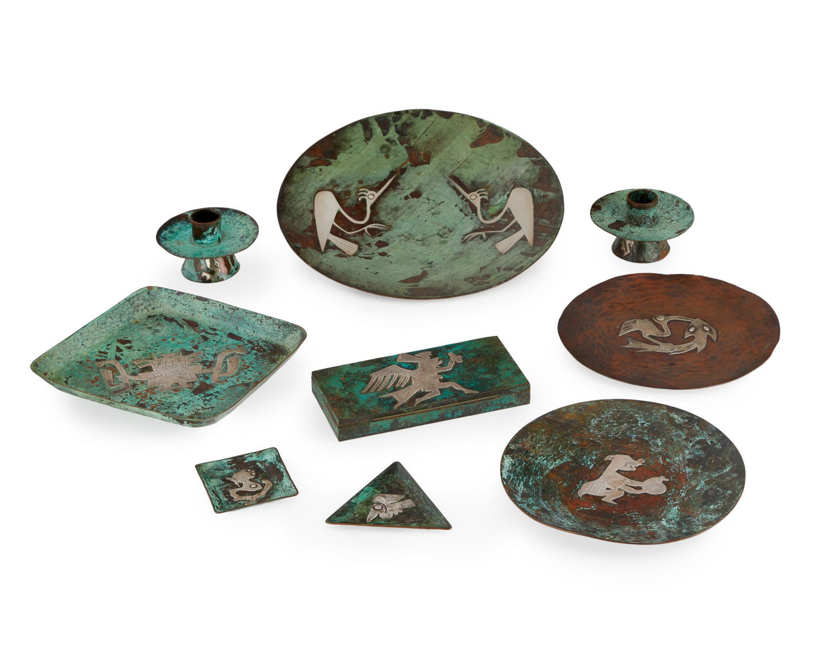 Nine Graziella Laffi mixed-metal table items: Third quarter 20th century; Peru Each stamped for Graziella Laffi; Further stamped: Peru Each with applied silver decorations, comprising a pair of candlesticks, a humidor, a footed tray, two small tr