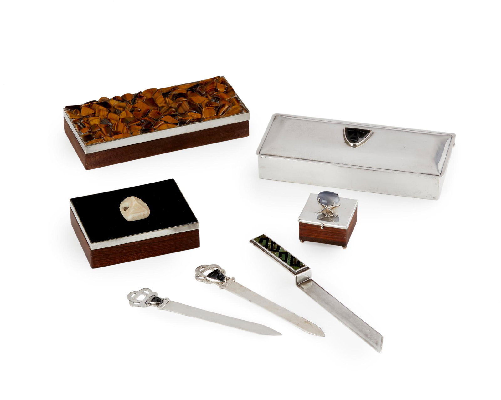 A group of Mexican silver and wood desk items: Third quarter 20th century; Mexico Each stamped for maker; Some further stamped for sterling silver Comprising a tiger's eye-set Los Castillo box, a Los Castillo box with face, one small box with ston