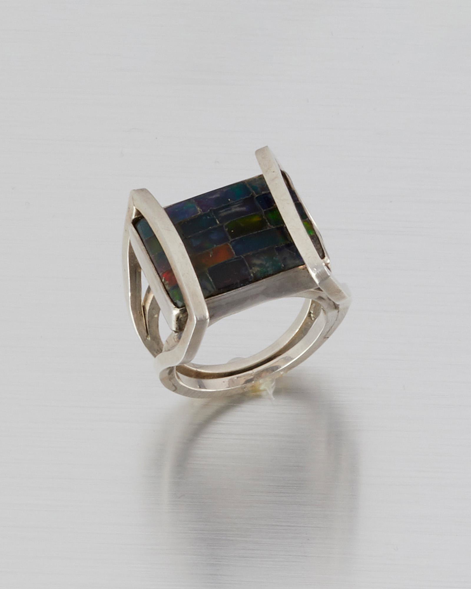 A Carmen Beckmann silver and black opal mosaic ring: Third quarter 20th century; Taxco, Mexico Stamped: Beckmann; Further stamped: Sterling / Mexico Designed with black opal mosaic tablets set into a silver-wrapped frame Ring size: 9 13.0 grams Provenan
