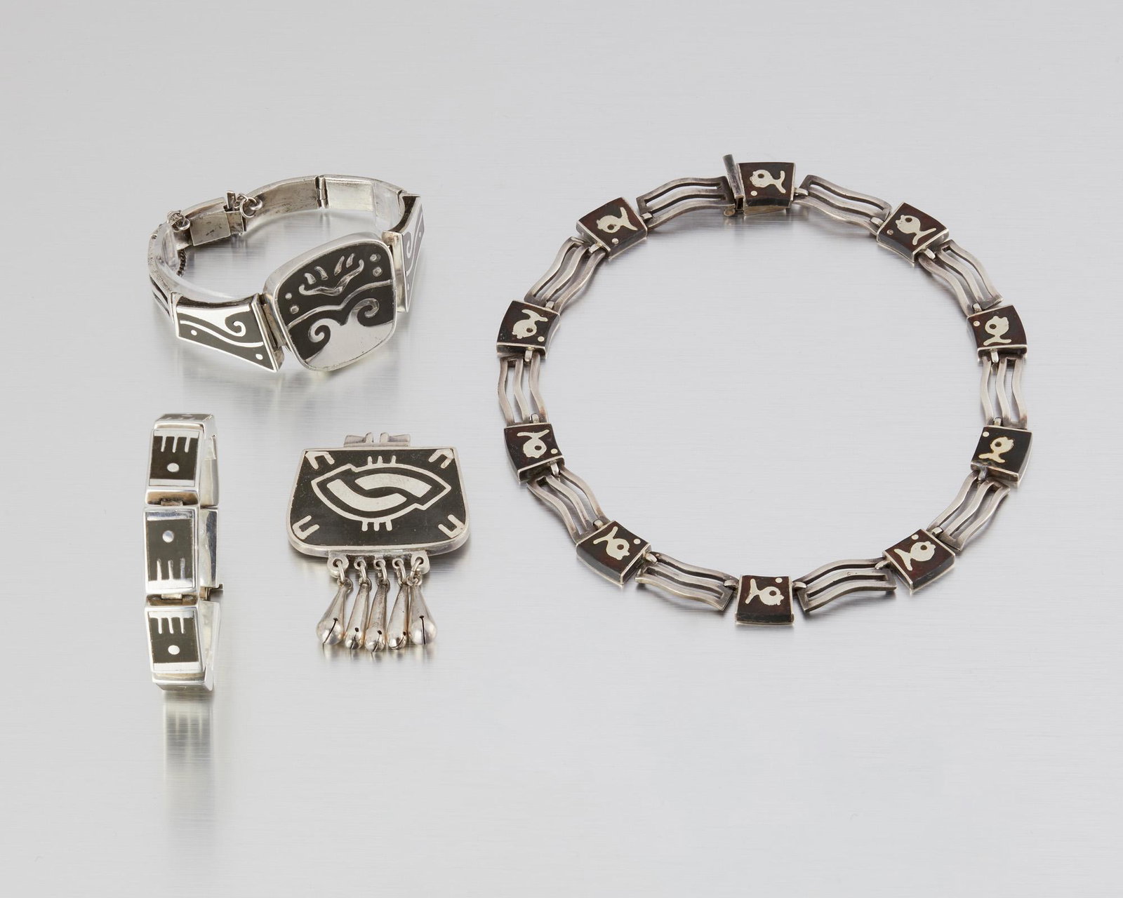 A group of Los Castillo silver "Onix Negro" jewelry: 1950-1970; Taxco, Mexico Stamped: Los Castillo; Eagle 15 or Indistinct Eagle; Each variously stamped: Onix Negro / 44 / A / 43 / Hecho en Mexico / 30 / 92 Comprising a necklace, two bracelets, and a b