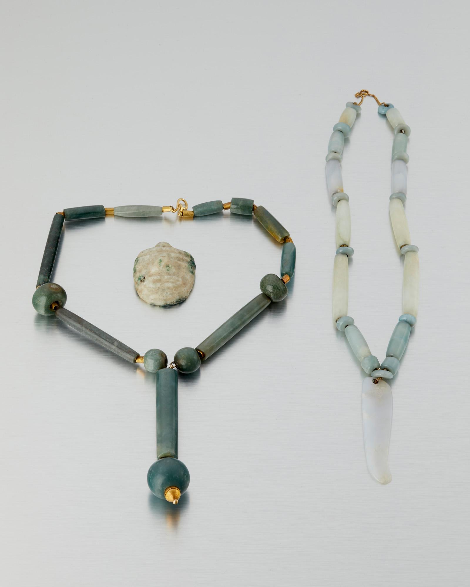 Three Pre-Colombian-style jade items: Pre-historic or later Comprising a jade and tumbaga bead necklace, a jade bead necklace, and a jade Pre-Columbian Olmec-style carved mask, 3 pieces Drop: 5.5" H x 1" W; Necklace: 19" L; Drop: 3" H x .