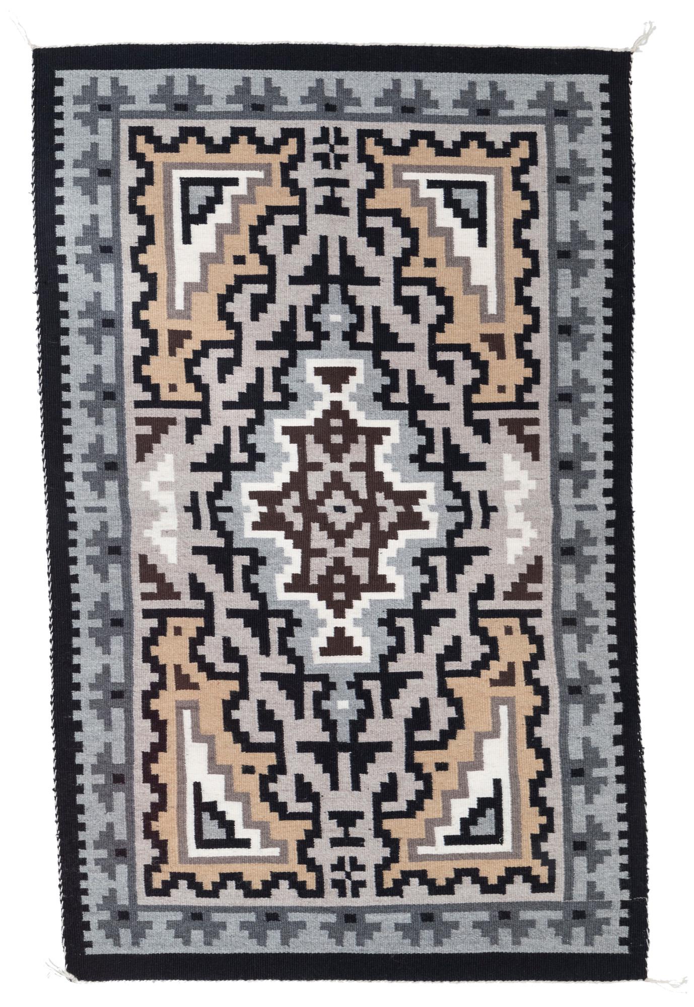A Navajo Two Grey Hills rug/weaving: A Navajo Two Grey Hills rug/weaving Fourth quarter 20th century Woven by Betty Wilson With a center diamond and elaborate all-over geometric designs all within a black border, woven in natural cream, 