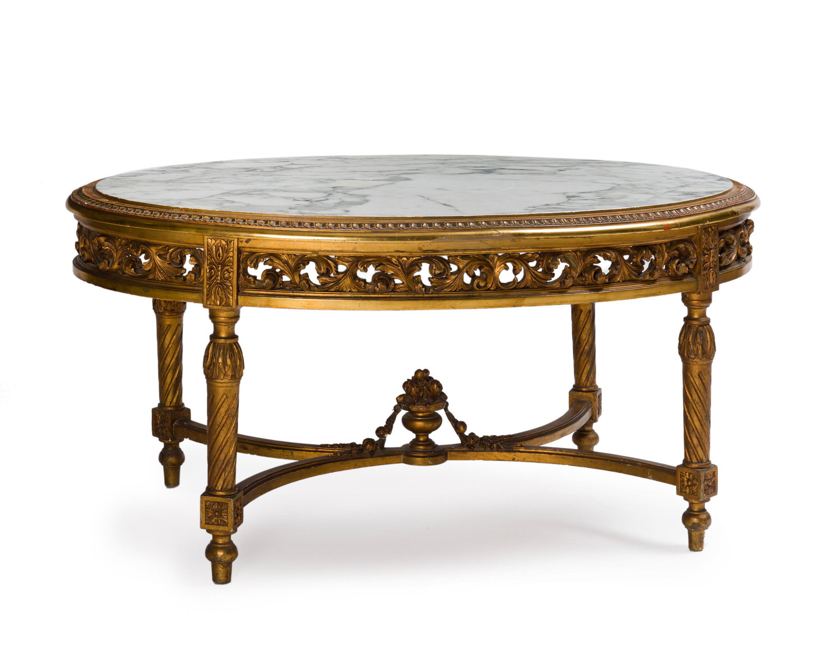 A French oval table with inset marble top: Late 19th/early 20th century The oval white marble top over a pierced and carved apron raised on fluted legs joined by X-form stretchers topped with a floral urn 23" H x 47.125" W x 31.325" D