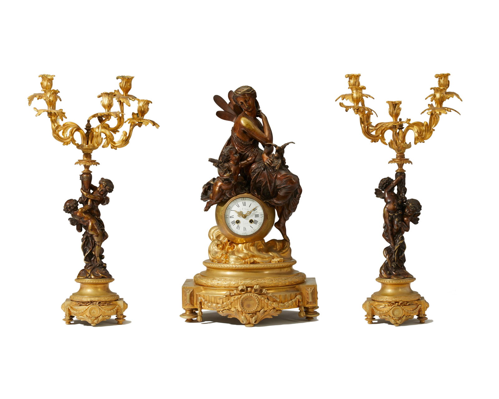 A French gilt and patinated bronze clock and garniture: Late 19th/early 20th century Dial signed: Japy Freres Cie / Med. D'Honneur; Further stamped: E.P Lepsse 5424 Surmounted by a patinated bronze figure of Psyche and Cupid over white porcelain dial parti