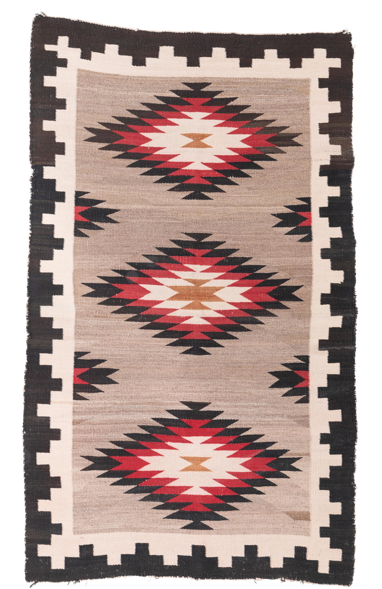 A Navajo regional rug: Second-quarter 20th century The rug with serrated diamonds woven in red, black, cream, and light gray 56" H x 34" W