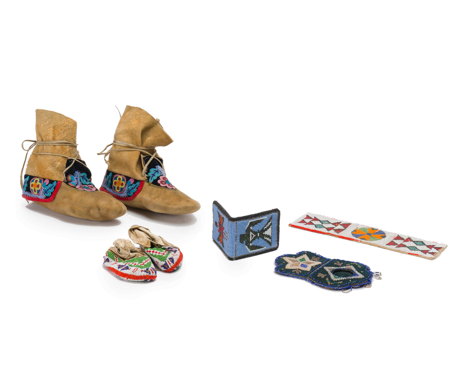 A group of American Indian beaded articles: First half 20th century Wallet stamped: Amity Comprising a pair of Cree polychrome foliate beaded moccasins, a fully beaded pair of Sioux child's moccasins, a beaded eagle-motif leather wallet, a bead