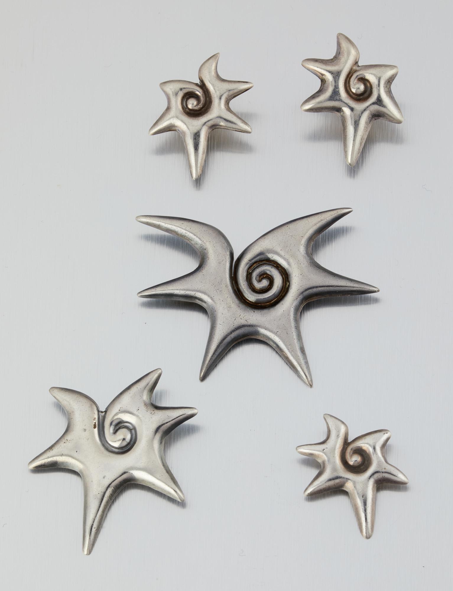 A group of William Spratling "Choluteca Conch" jewelry: 1940-1944; First Design Period; Taxco, Mexico Each stamped for William Spratling; Further stamped: Made in Mexico / Spratling Silver Comprising three brooches/pins of three different sizes and a pair 