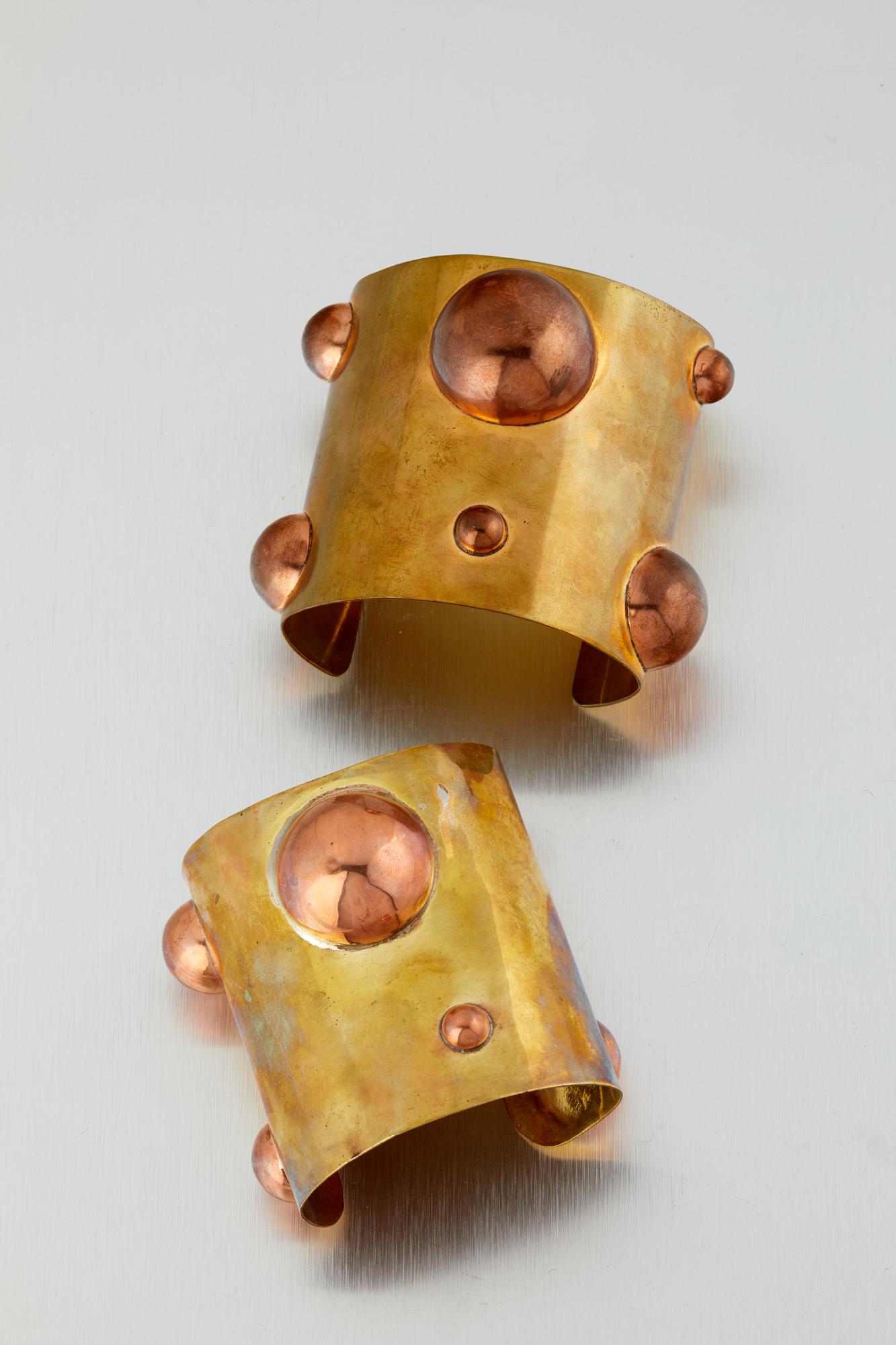 Two Hubert Harmon mixed-metal cuff bracelets: 1942-1948; Taxco, Mexico Each stamped for Hubert Harmon; One stamped: Mexico Each designed with copper spheres on a brass cuff, 2 pieces Larger: 7.25" C x 2.75" W, wrist opening: 1.75"; Smaller: 6.