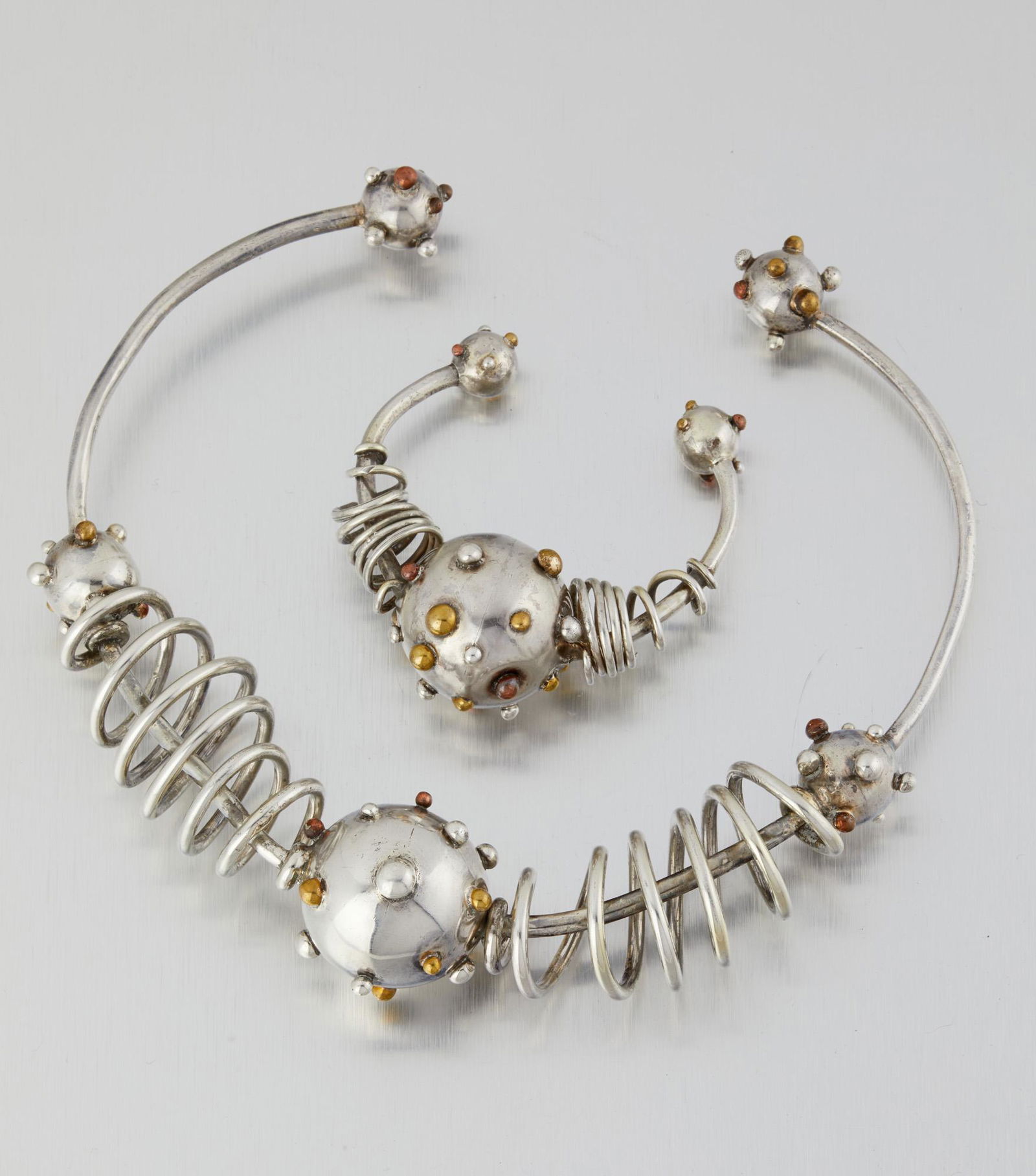 Two Hubert Harmon bomb-motif mixed-metal jewelry items: 1944-1948; Taxco, Mexico Bracelet indistinctly stamped; Further stamped: Mexico / Sterling Comprising a rigid collar necklace with mixed metal "bombs" and a matching cuff bracelet, 2 pieces Necklac