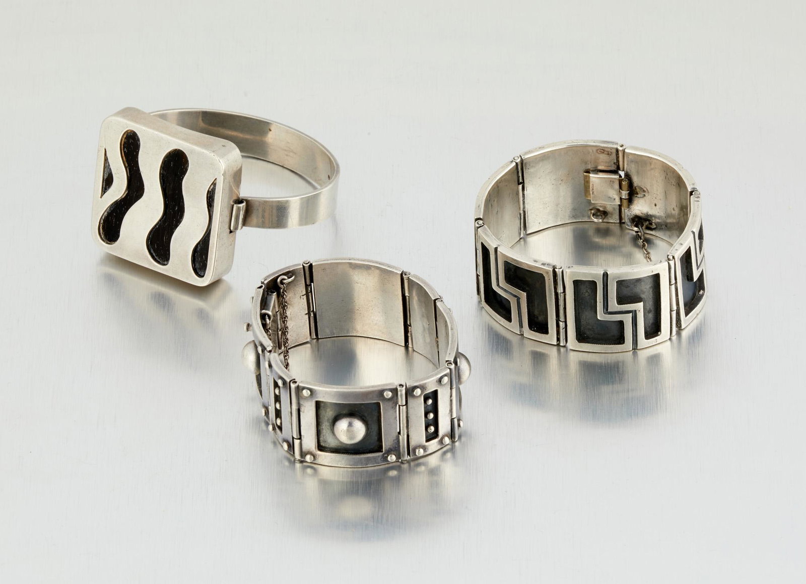 Three Los Castillo silver bracelets: 1942-1948 and 1948-1955; Taxco, Mexico Each stamped for Los Castillo and sterling silver Comprising a two-tone geometric link bracelet (6.75" L x 1" H); A dome and rivet-style link bracelet (6.25" L x