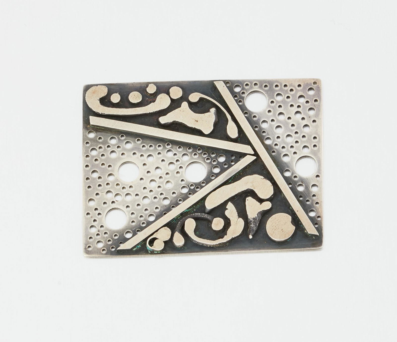 A James Parker Modernist sterling silver pendant: Third quarter 20th century; San Diego, CA Stamped for James Parker; Further stamped: Hand Made / Silver Designed in two-toned silver with pierced design 2.25" H x 1.75" W 30.0 grams Provenance: