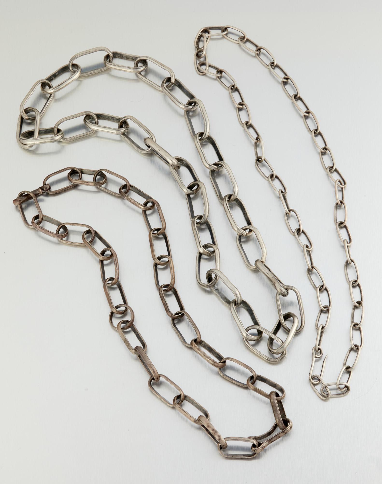 Three silver chain necklaces: Third quarter 20th century The smallest stamped: Sterling JD Each made of oversized links with hook clasps, 3 pieces Largest: 39.5" L x .875" H; Medium: 35" L x .75" H; Smallest: 37" L x .5" H 986.0 g