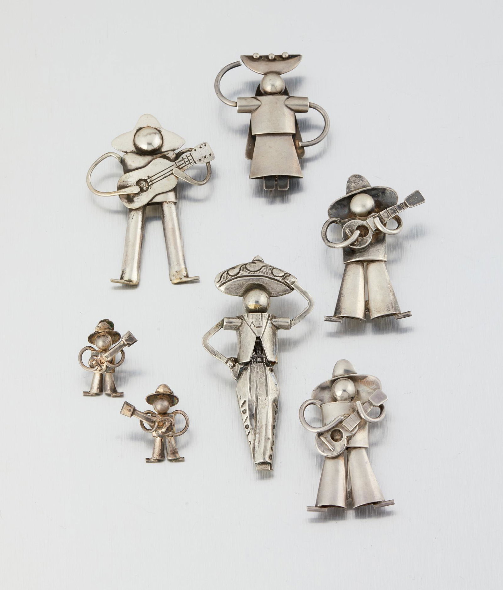 A group of Fred Davis silver figural jewelry: Pre-1948; Mexico City, Mexico Stamped: FD for Fred Davis; Further stamped: Silver / Made in Mexico Comprising a group of figural jewelry including five brooches and a pair of guitar playing figure scr