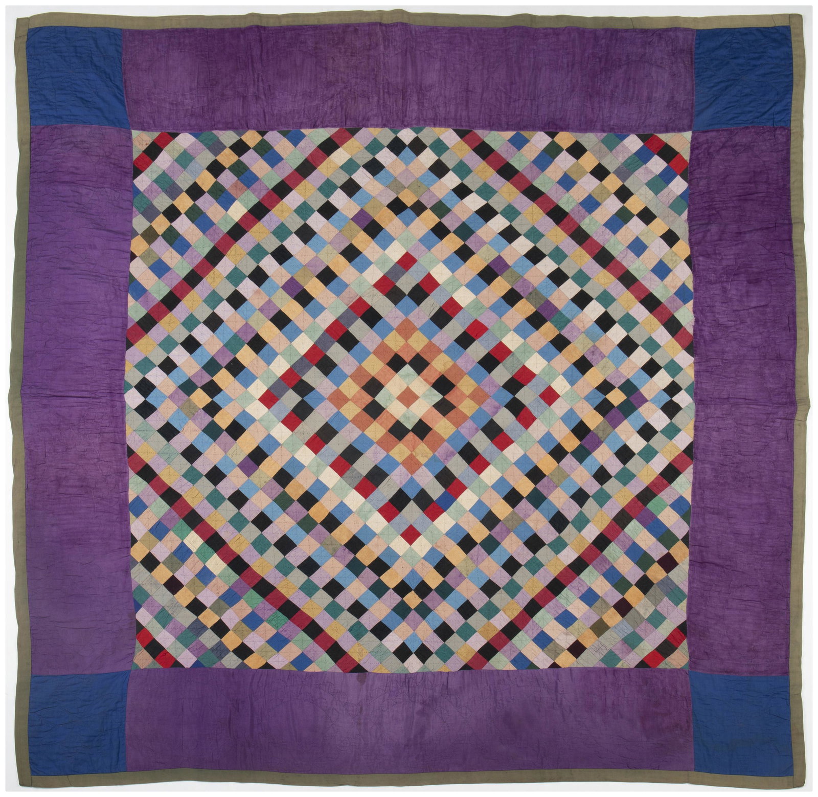 An Amish Sunshine and Shadow quilt: 1920-1930, Lancaster, Pennsylvania Cotton with radiating multicolored diamonds, a purple border, and blue corners, hand-quilted in cross hatching, interlocking ovals, scallops, and eight-pointed stars