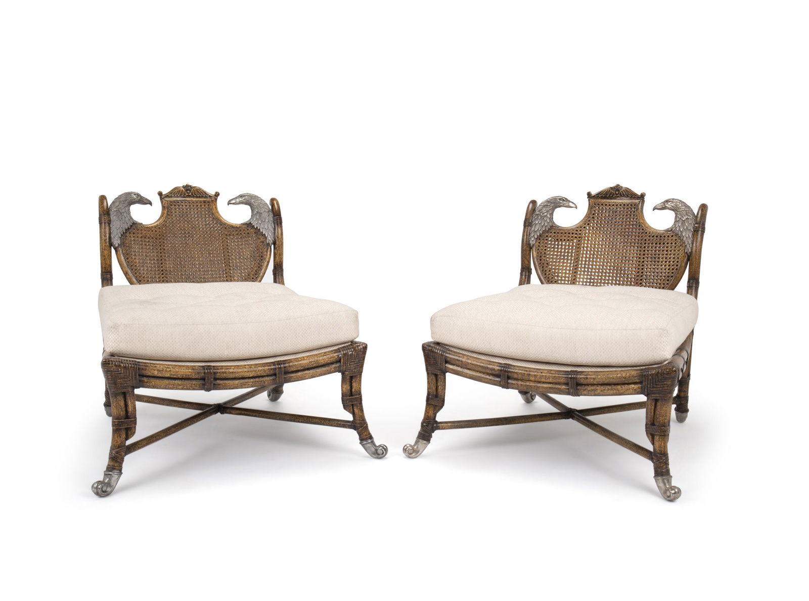 A pair of Maitland Smith caned chairs: Fourth-quarter 20th Century Apparently unmarked Each caned back flanked by metal eagle heads with attached beige button-tufted seat and metal scroll feet, 2 pieces Each: 31.625" H x 28" W x 32" D