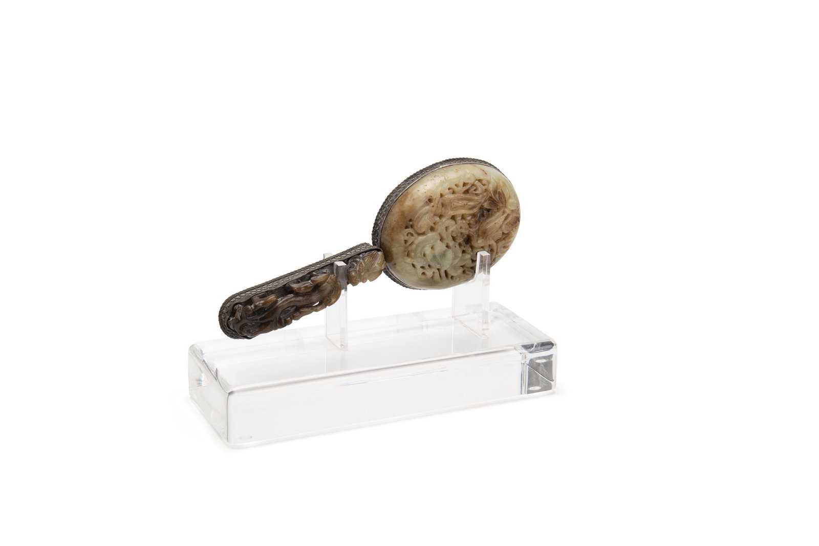 A Chinese silver and carved stone hand mirror: Mid-20th Century The oval mirror set in a decorative silver frame with dragon-motif carved back and handle set on a custom Lucite stand 9.75" H x 3.625" W x 1.5" D