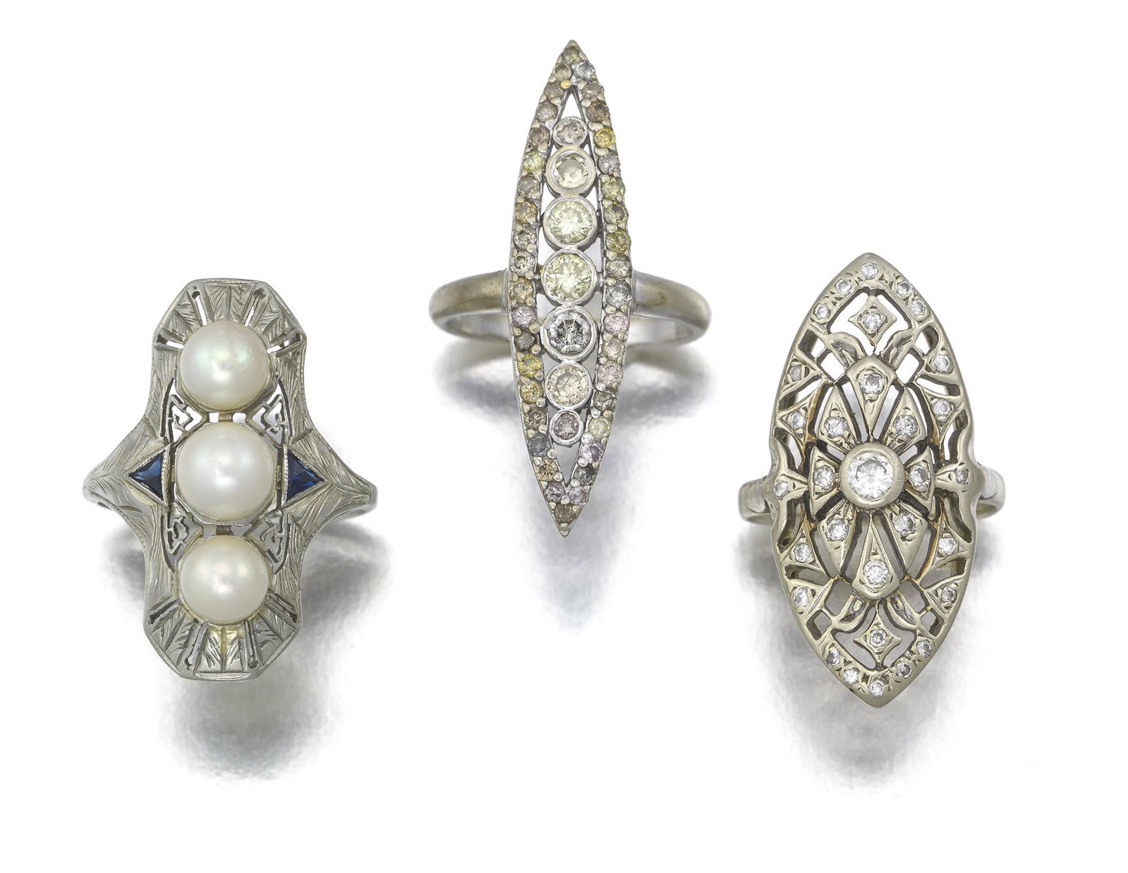 Three navette-shaped gem-set rings: 18k and 14k white gold Comprising an 18k white gold cultured pearl and simulated sapphire ring (8.5), an 18k white gold and colored diamond ring (7.25), and a 14k white gold and diamond ring (6.75) 17