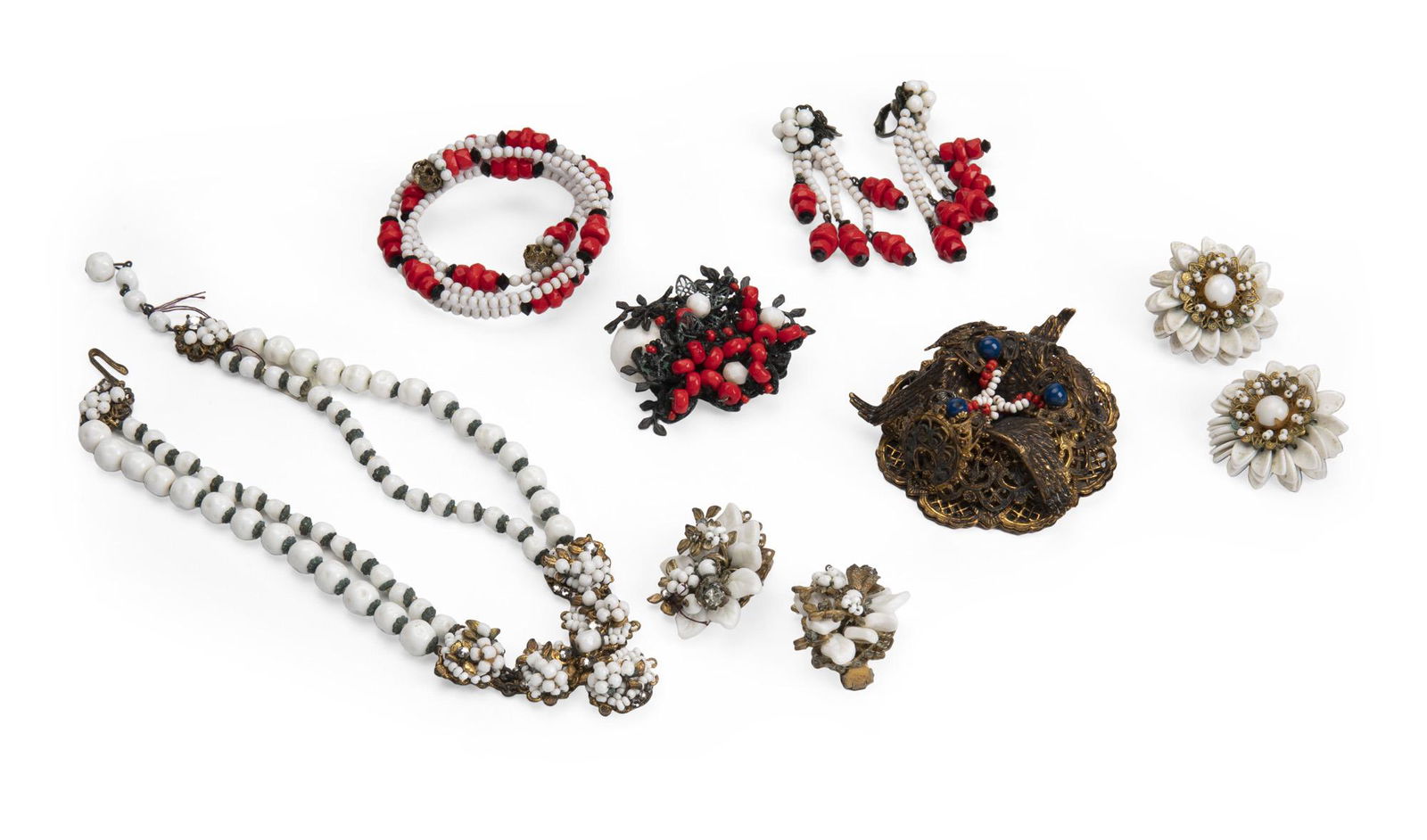 A group of Miriam Haskell glass jewelry: Comprising a set with white beads (two pairs of clip-back earrings and a choker), a set of red and white jewelry (brooch, wrap bracelet, and ear clips), and a large blue, red, and white bead brooch N