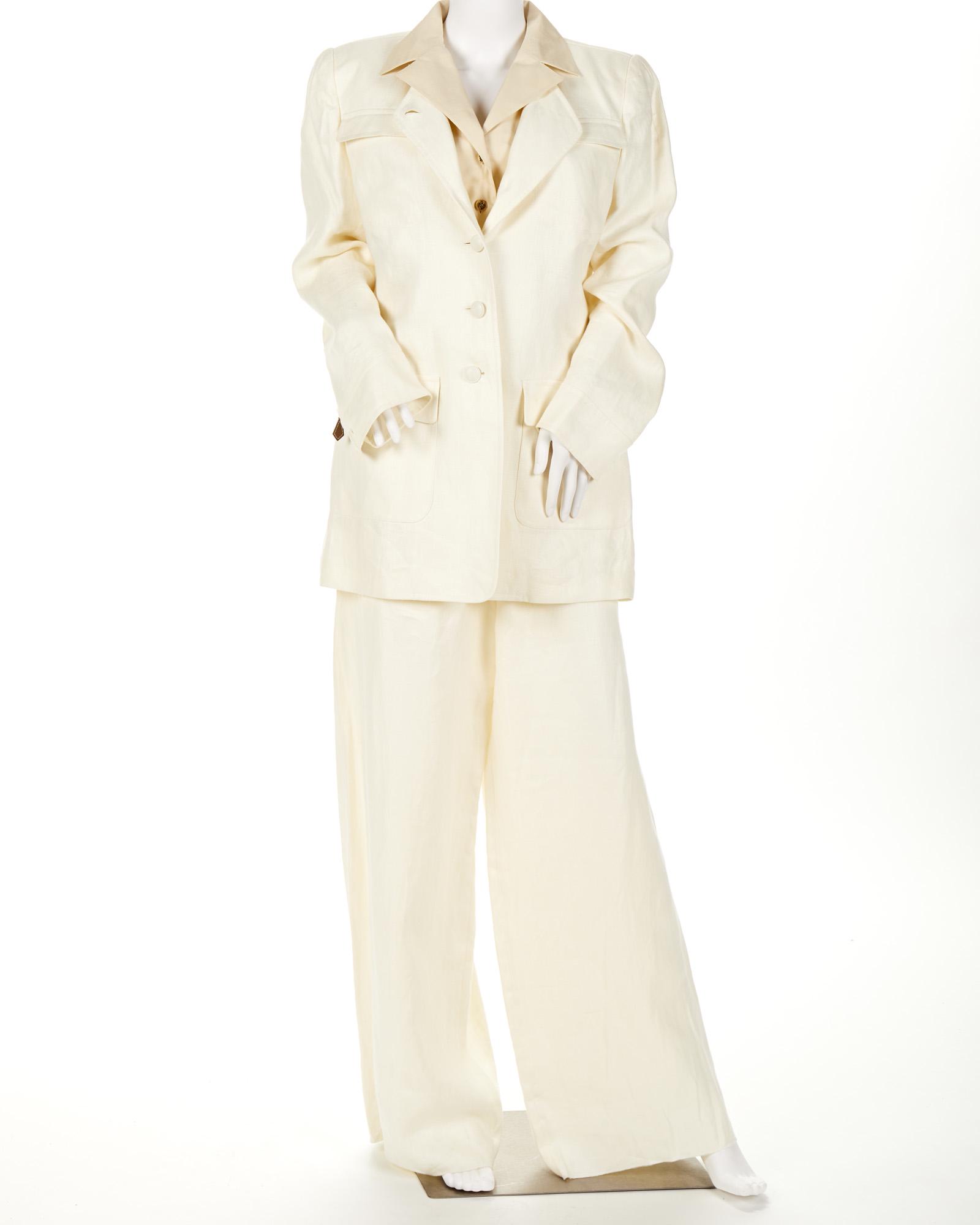 A white Hermes suit and a blouse: Fourth quarter 20th century Fabric label: Hermes Paris Comprising a collarless jacket and pant (size 48) together with a cream blouse (size 40) 3 pieces