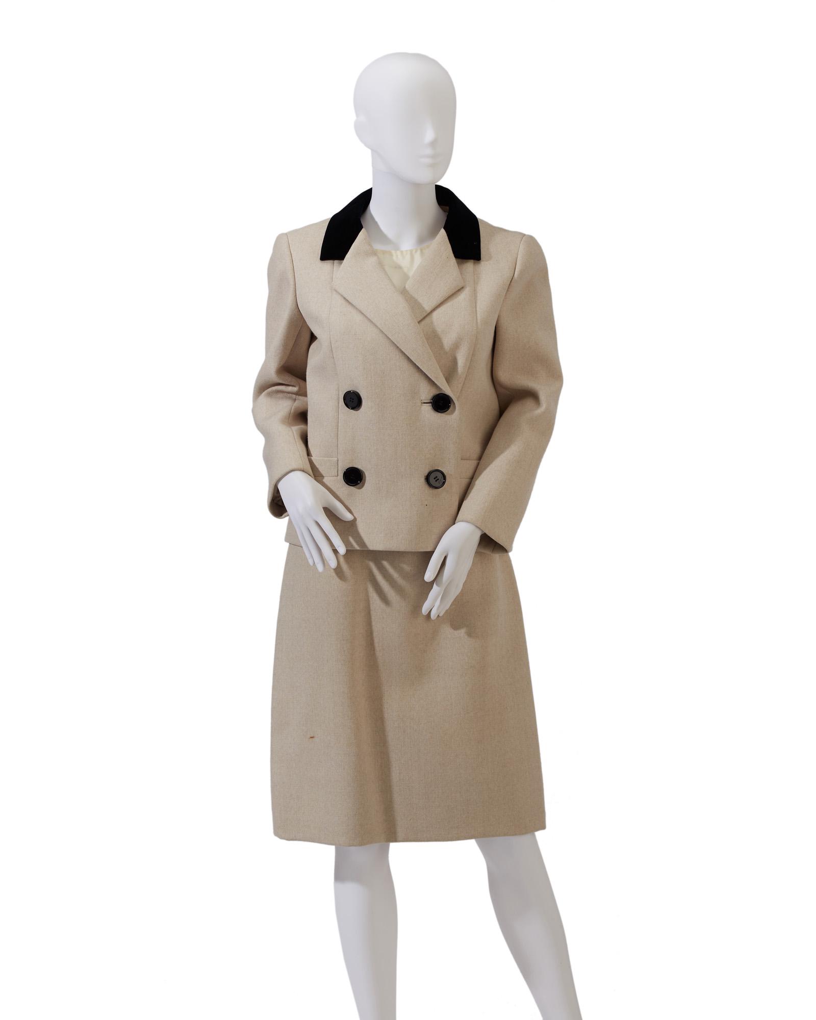 A Norman Norell skirt suit: Early 1960s Fabric label: Norman Norell / New York; Fabric label for retailer: Julius Garfinkel & Co. / Washington D.C. The cream suit with velvet collar together with a matching underdress sewn to a 