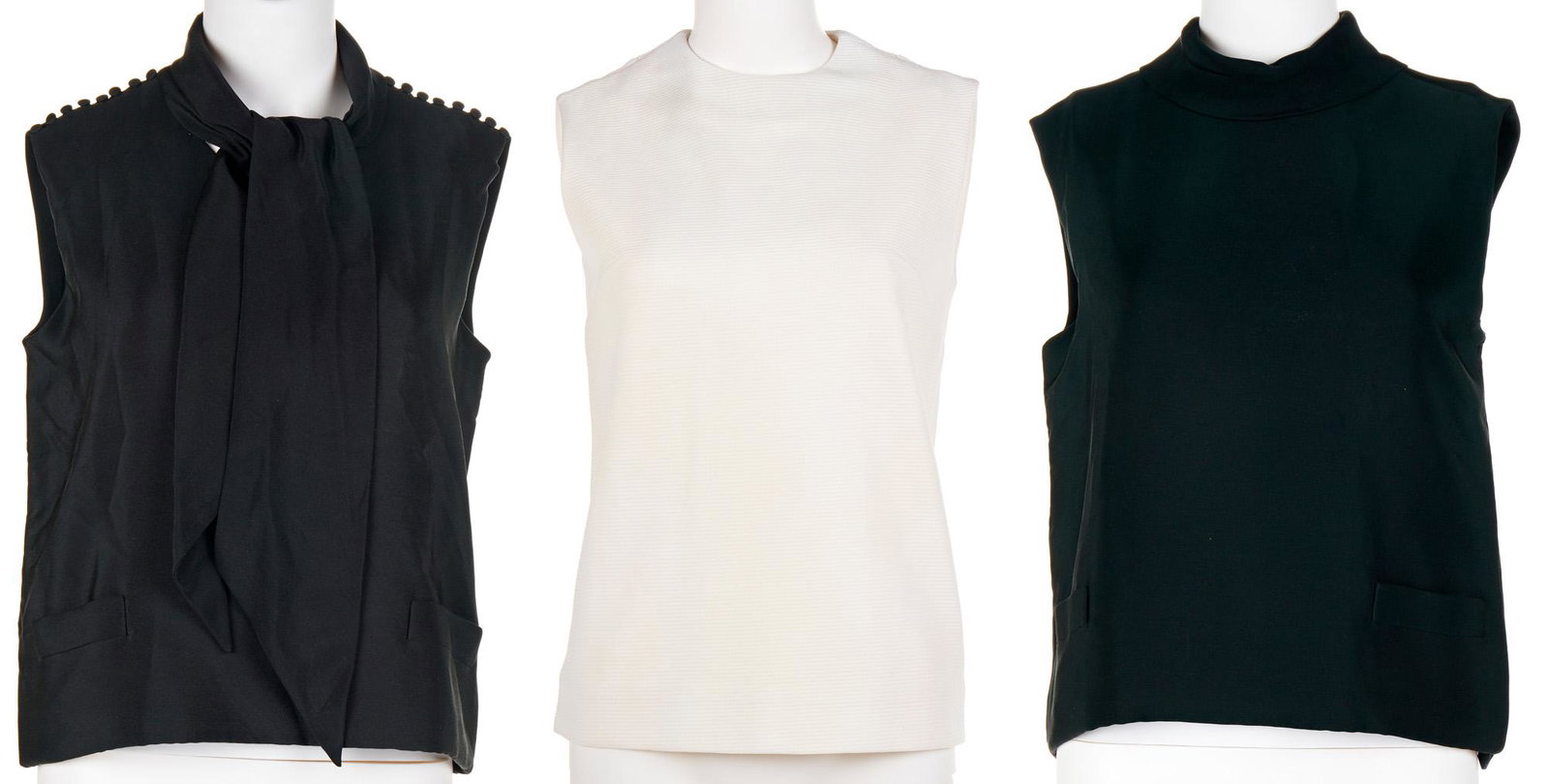 Three sleeveless blouses: Circa 1960s Each with fabric label Comprising one white Emma blouse, a black rolled collar Norman Norell blouse, and a black Norman Norell blouse with tie and buttons at shoulders (the last two with s