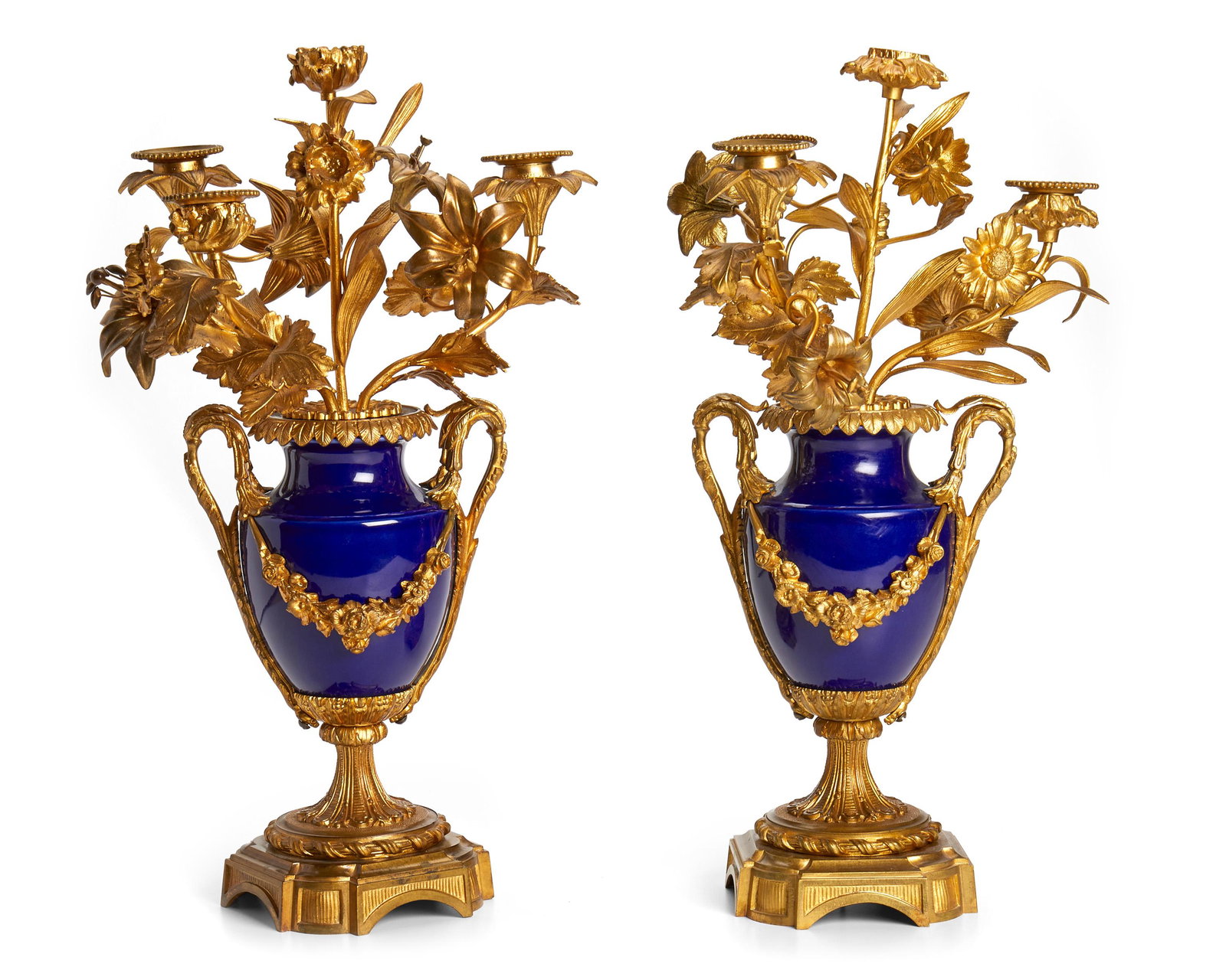 A pair of French gilt bronze candlelabra: Late-19th/early-20th Century Each four-light candelabra with floral and leaf arms extending from a cobalt blue urn body on a bronze pedestal, 2 pieces 17.25" H x 10.5" W x 8" D