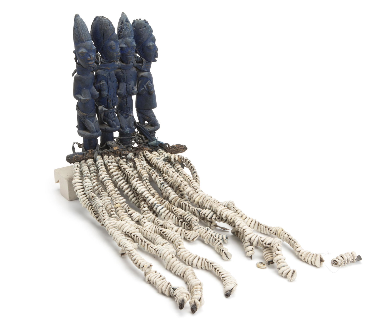 An African Eshu fetish: Yoruba culture, Nigeria Four laundry blue figures representing worshipers of the cult of Eshu with cowry shell attachments 31" H x 10" W x 2" D Provenance: Harry Franklin Galleries, Beverly Hills, CA 