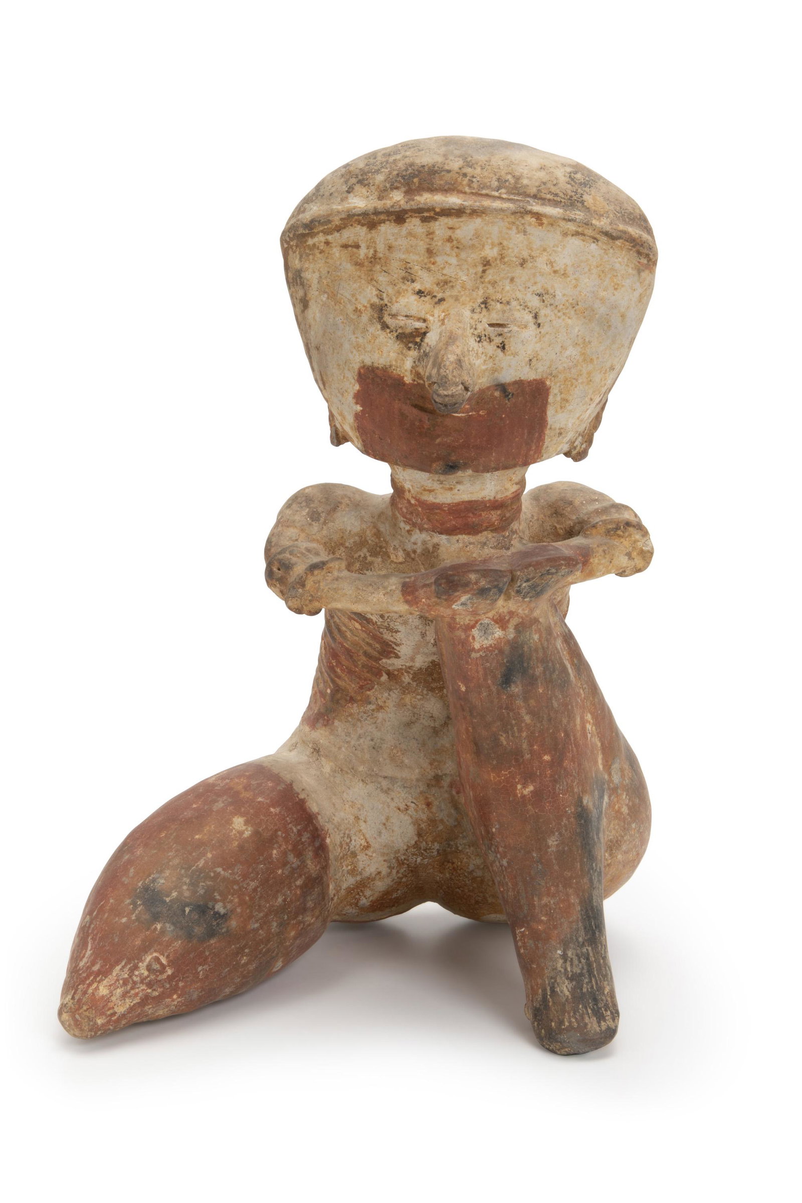 A Pre-Columbian Chinesco-type terracotta figure: Circa 250 BCE-250 CE; Nayarit (West Mexico) The seated male earthenware figure with white-cream decorations on burnished red slip with black patina displaying nose, ear, and arm ornaments with both ha