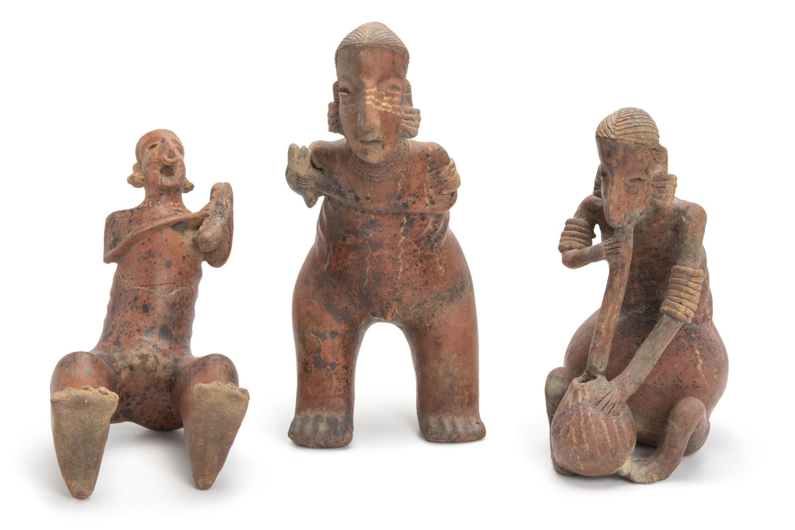Three Pre-Columbian terracotta musician figures: Circa 100 B.C.-500 A.D.; Nayarit (West Mexico) Comprising three terracotta musicians with earrings, armlets, and nose ornaments with emaciated back rib cages each showing various remnants of ancient
