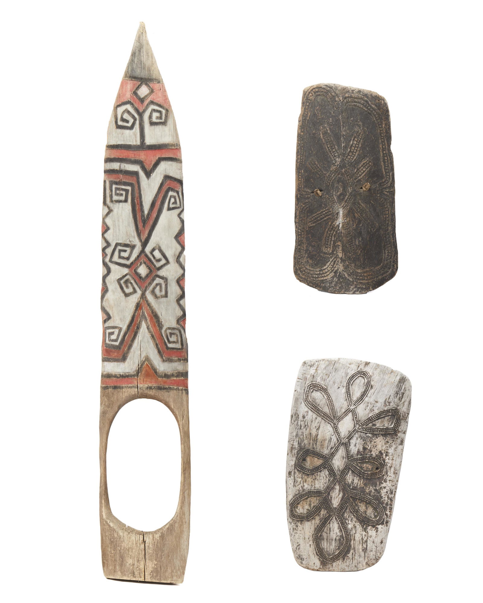 Three large Oceanic tribal items: Circa 1970s; Papua New Guinea Comprising two battle shields from the Simbai/Schrader Range with geometric decoration and one large painted wood door from Teleformin/Highlands with small entrance/exit,