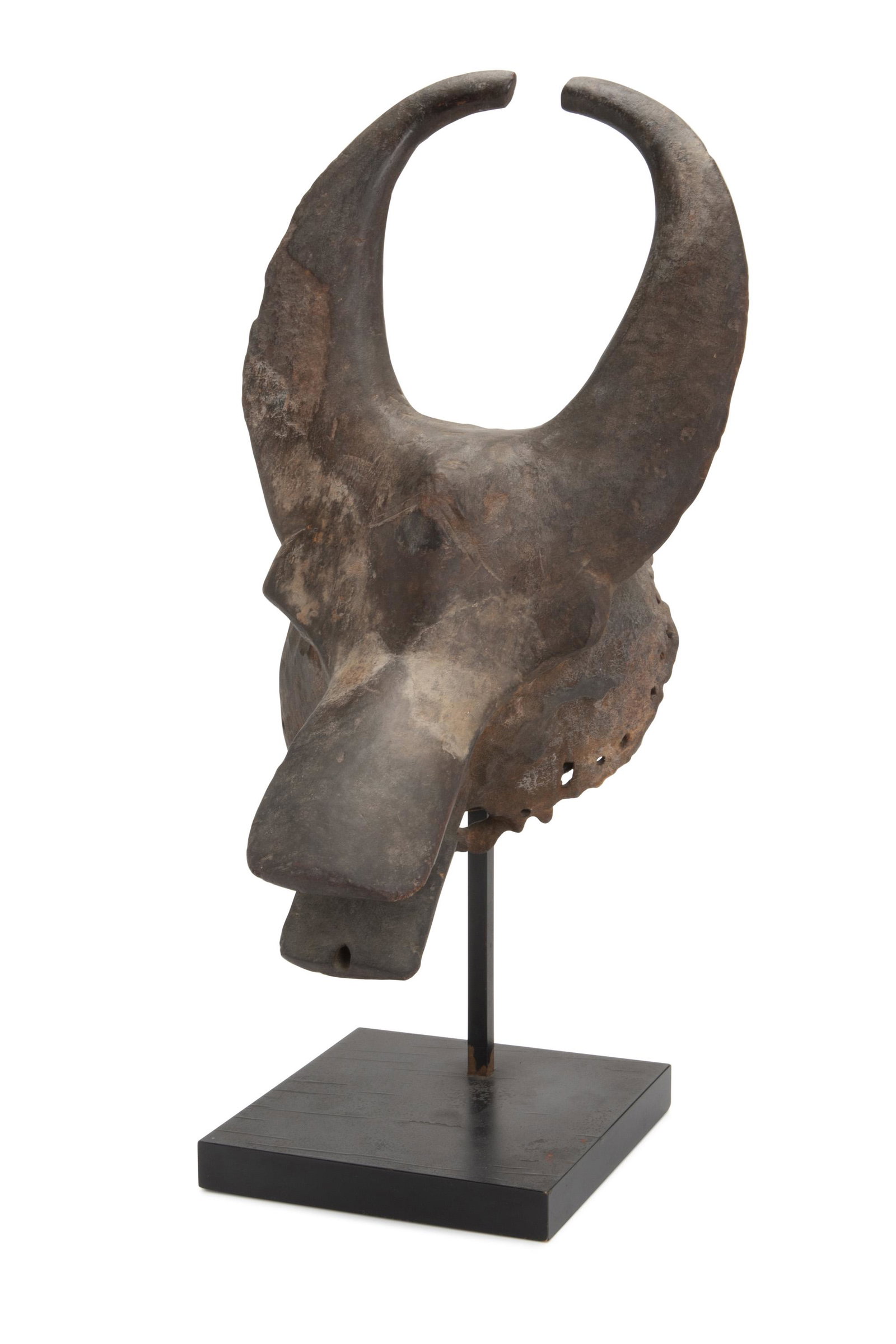 A Nigerian wood buffalo mask: Late-19th/early-20th Century; Mangam Cult or Mama culture, Nigeria The mask with two bar-shaped horns over a rectangular mouth, sides with drilled holes for attachment 16" H x 9.5" W x 10.5" D Provena