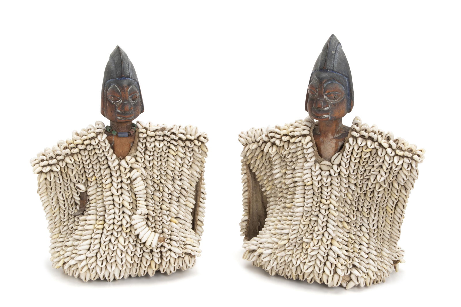 Twin African cowry shell figures: Yoruba culture, Nigeria The Yoruban wood figures each with indigo helmet and cowry shell decoration, one with a multicolored bead necklace, 2 pieces 10" H x 14.5" W x 7" D Provenance: PACE Galleries, 