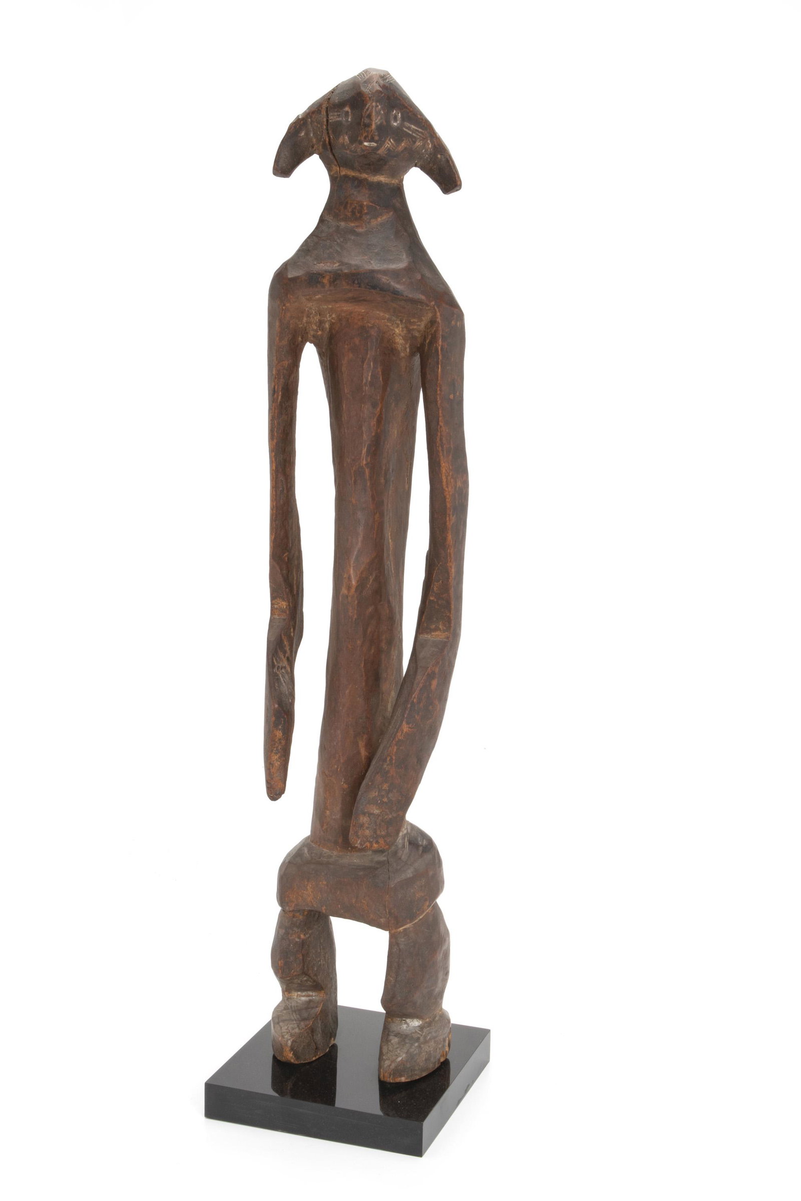 An African Mumuye ancestor figure: Late-19th/early-20th Century; Mumuye culture, Northern Nigeria The carved male figure with tribal designs incides on face and head with typical Mumuye-style coiffeur and pendant arms ending in paddle-