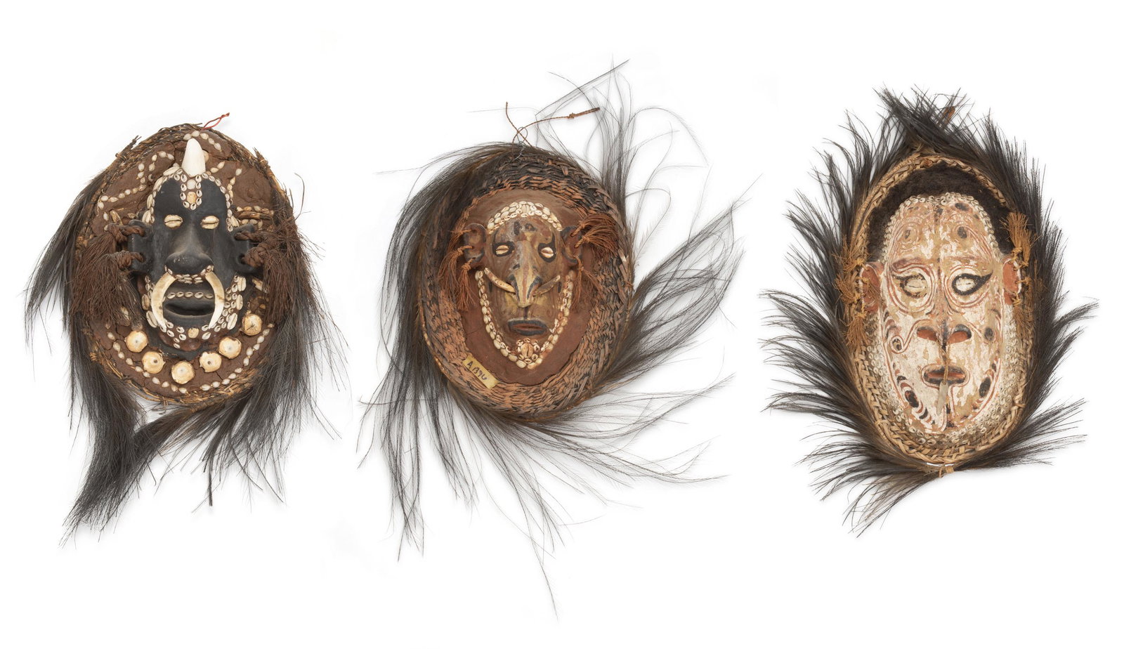 Three Oceanic ancestor face masks: Circa 1969; Middle Sepik River, Papua New Guinea Comprising three wicker, mud, shell, feather, and pigment face masks with cowry and nassa shell details in traditional form, 3 pieces Largest: 16" H x 