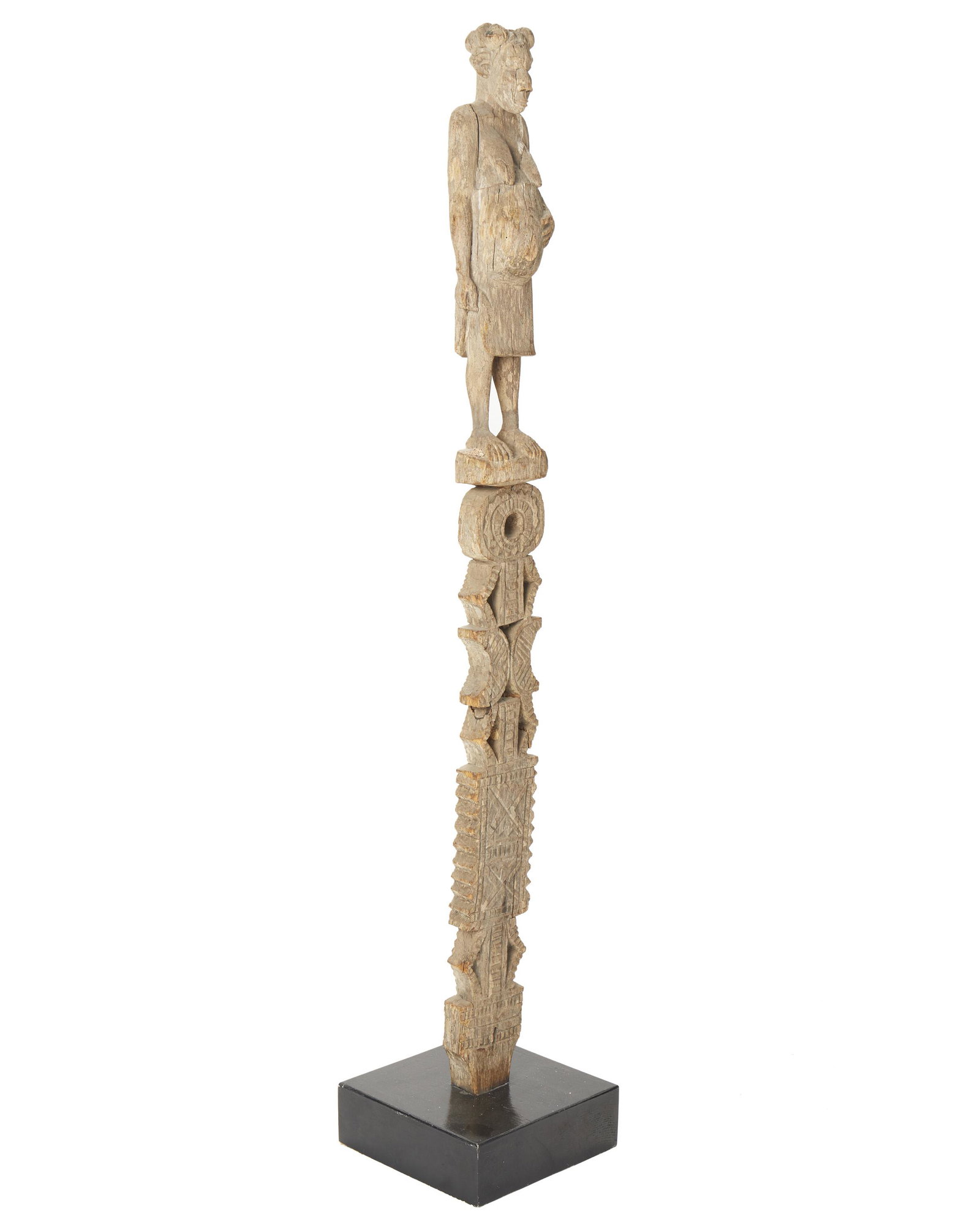 A figural grave post: Mahafaly culture; Southern Madagascar The wooden grave post with pregnant female figure over lozenge and crescent motifs 55" H x 5" H x 4" D Provenance: Rick Monsein Collection Shakti Gallery, Long Be