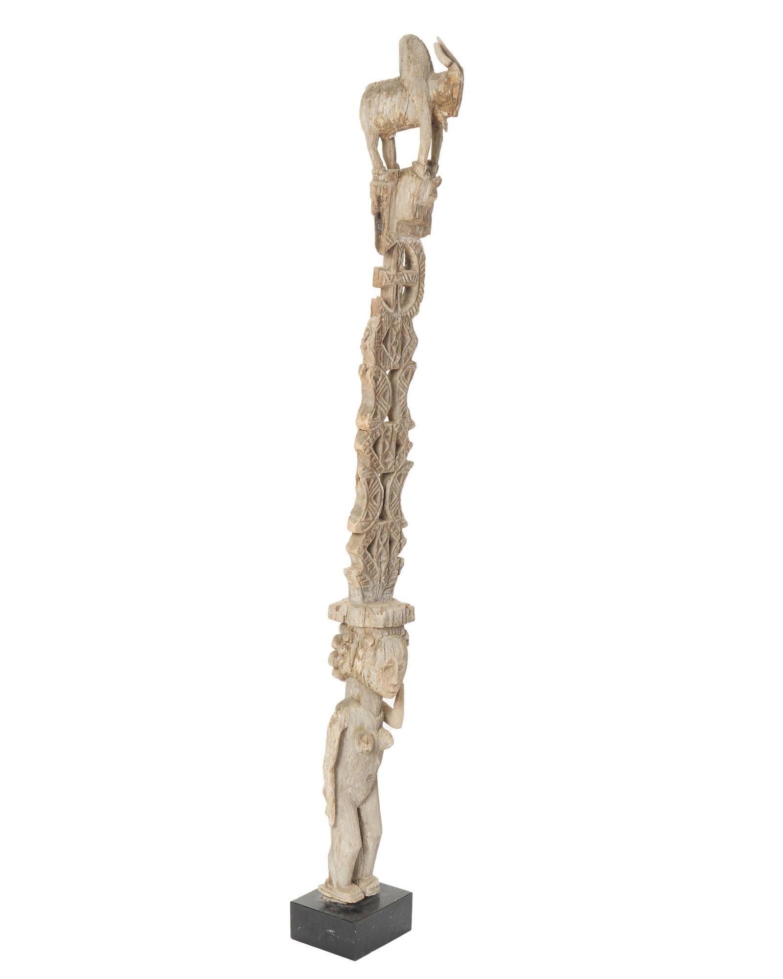 A figural zebu and woman grave post: Mahafaly culture; Southern Madagascar The intricately carved wood post with three dimensional bovine (zebu) and standing female figures separated by lozenge and crescent motif carvings 68.5" H x 7" W 