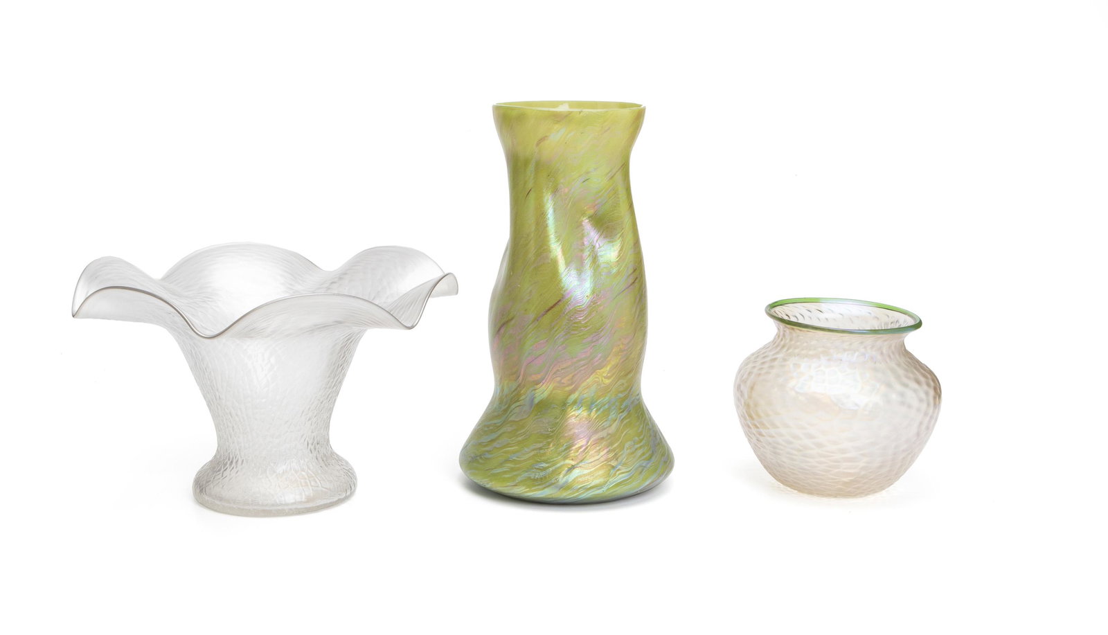 Three Loetz-style objects: Late-19th/early-20th Century Apparently unmarked Comprising a tall iridescent apple-green vase with slightly pinched rim, a clear low vase with wide vacillating rim, and a frosted iridescent clear low