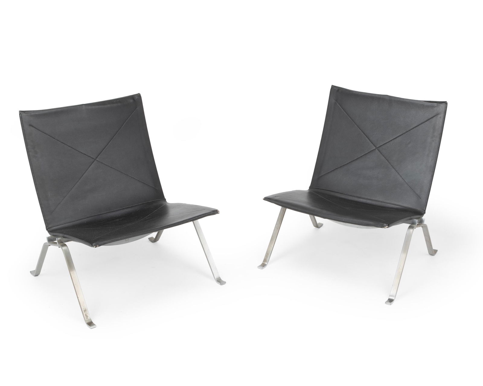 Poul Kjaerholm (1929-1980, Danish): A pair of PK22 side chairs Chromed metal and black leather Each labeled: Fritz Hansen / Made in Denmark / 1984 Each approximately: 27.5" H x 24.5" W x 24.5" D Notes: The Fritz Hansen PK22 Chair w
