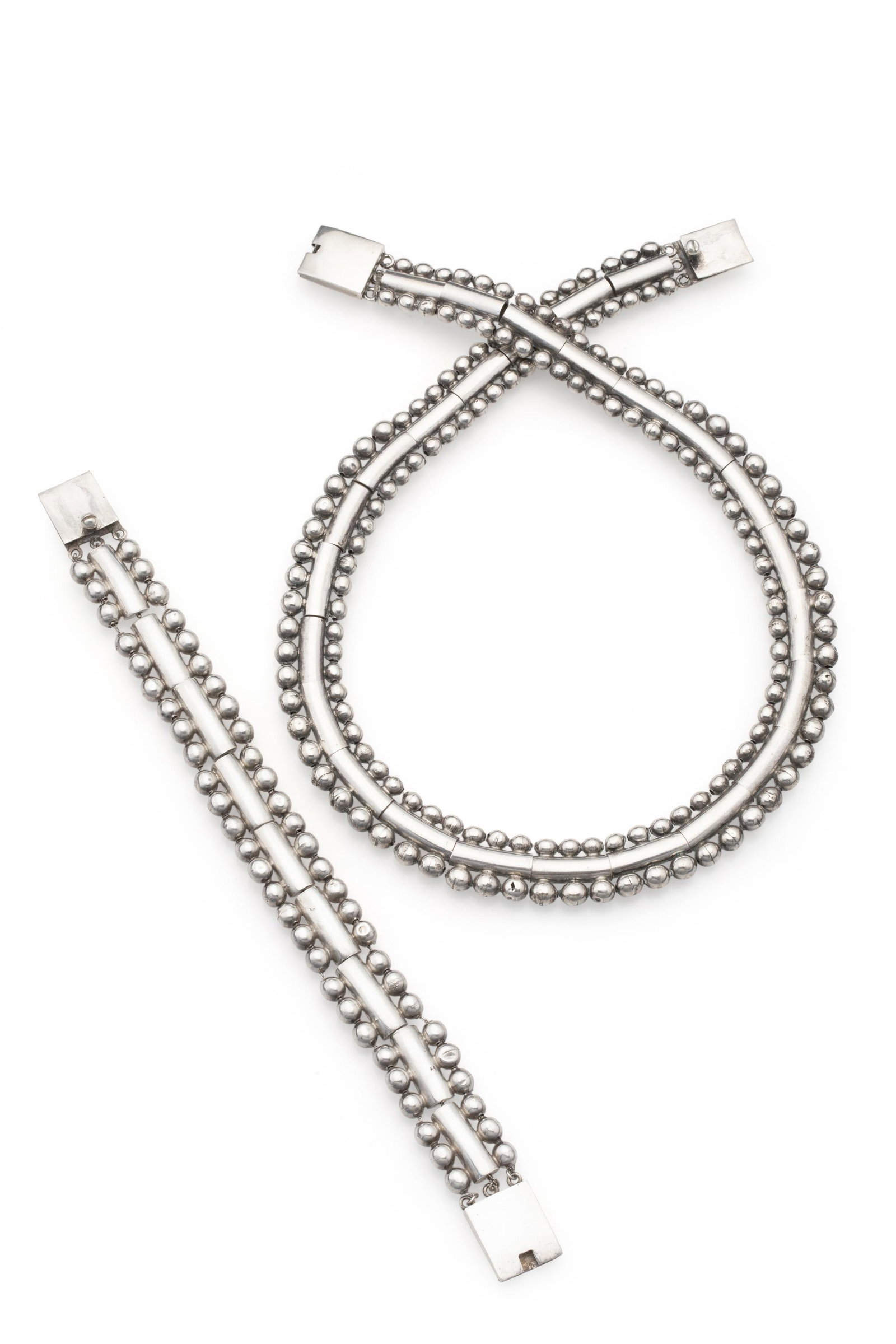 A set of William Spratling sterling silver jewelry: 1956-1962; Third Design Period; Taxco, Mexico Each stamped for William Spratling; Both stamped: 925 / Taxco Mexico / indistinct eagle The matching necklace (17" L x .625" H) and bracelet (7.5" L x .62