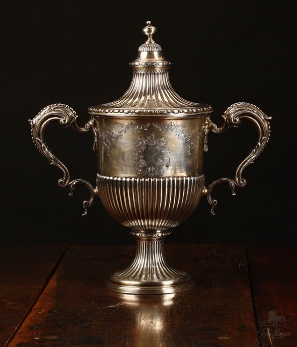 A George III sterling silver double-handled urn: 1768, London, with maker's mark ''CW'', possibly Charles Woodward or Charles Wright, the knob finial above a fluted circular lid over a tapering reeded body, with foliate-sheathed scroll handles to si
