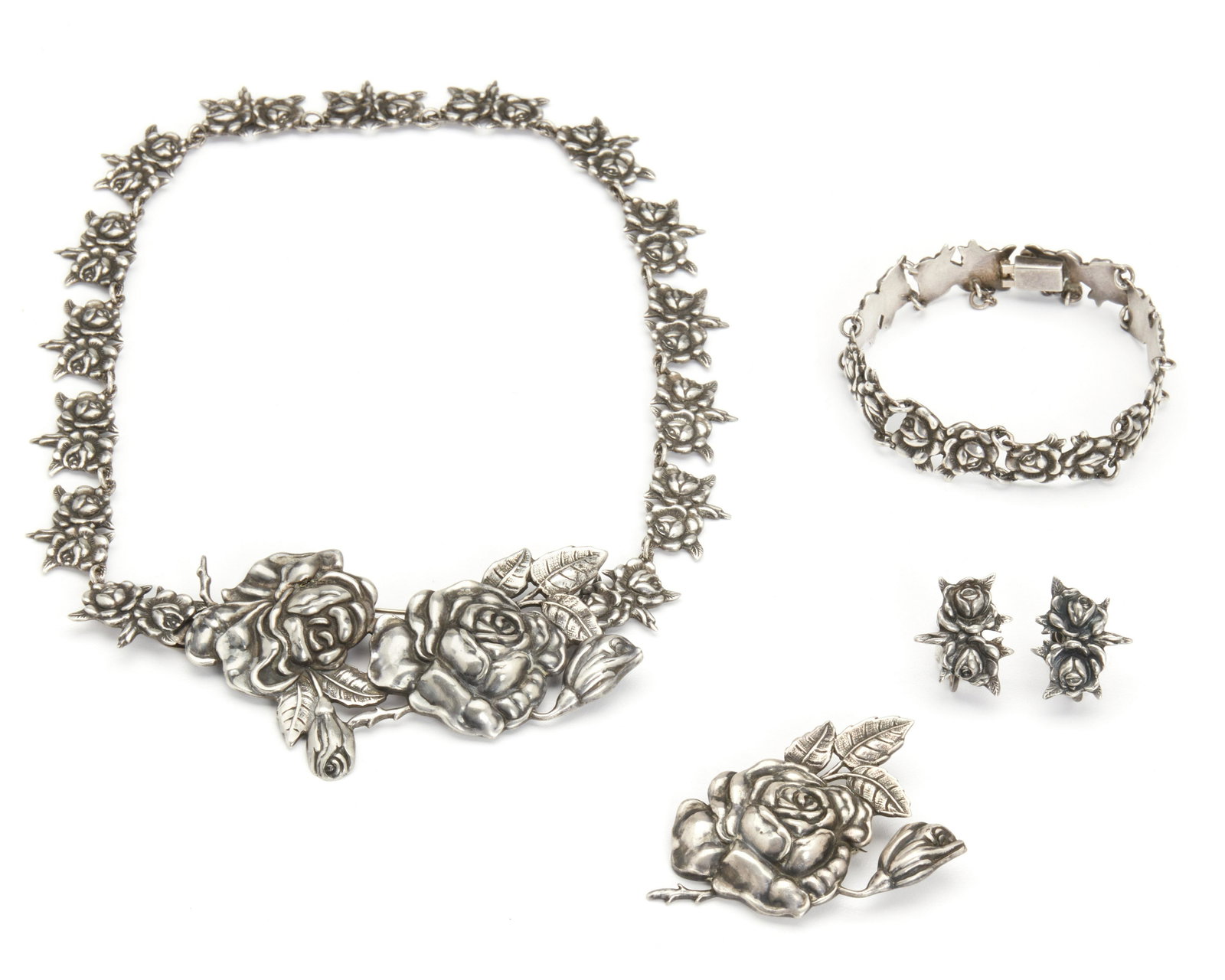 A suite of Margot de Taxco silver rose-motif jewelry: Third quarter 20th century; Taxco, Mexico Each stamped: Margot de Taxco / Hecho en Mexico / Eagle 16; Each further numbered: 5352 or 5194 Designed by Margot Van Voorhies, comprising a rose-motif penda