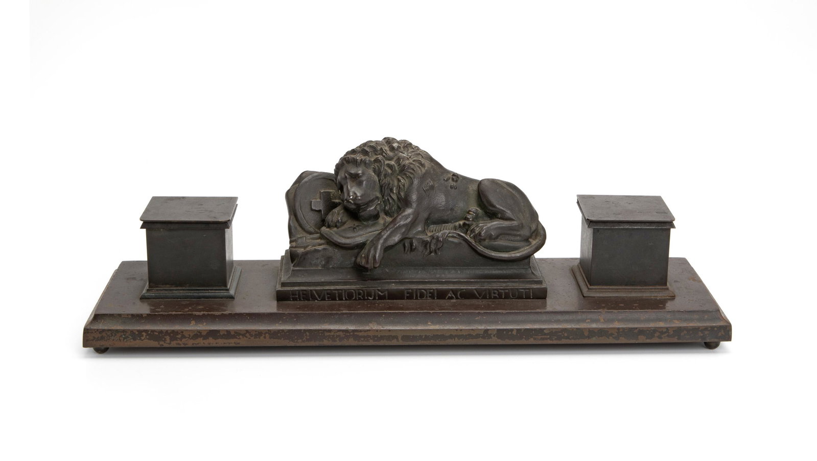 A bronze Swiss "Lion Monument" double inkwell: First-half 20th Century With a central reclining lion above the phrase "Helvetiorum Fidei Ac Virtuti," designed after the rock monument in Lucerne, Switzerland commemorating the Swiss Guards massacred