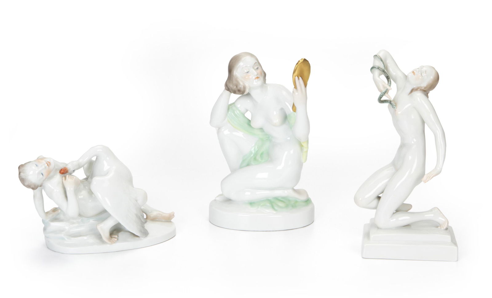 Three Herend nude figures: Second-quarter 20th Century Each marked for Herend Comprising a woman with a hand mirror, "Leda and the Swan," and "Cleopatra," 3 pieces Largest: 9.325" H x 5.325" W x 3.5" D