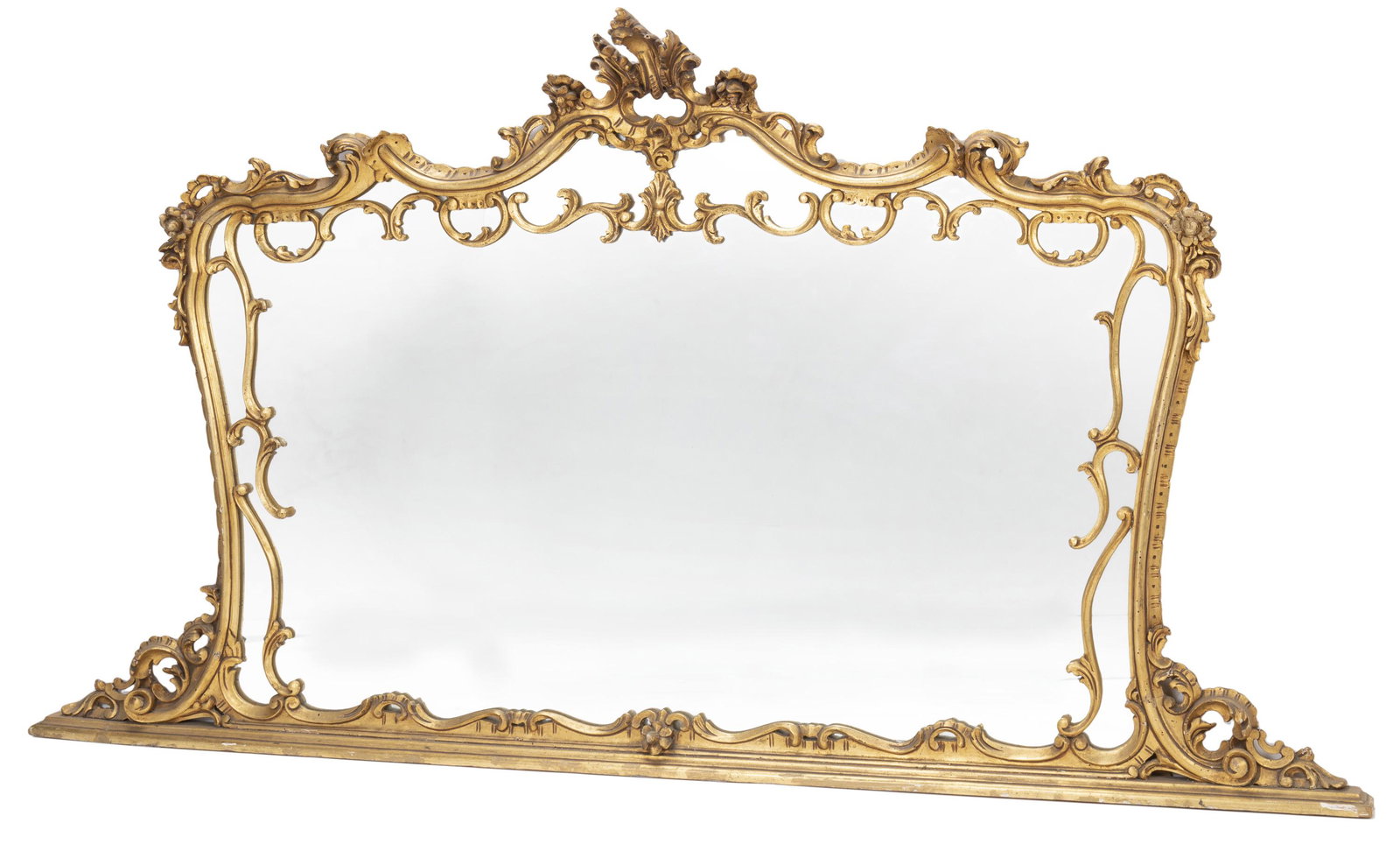 A Continental Rococo-style giltwood wall mirror: Late 19th/early 20th Century The carved open-work foliate cornice atop a carved rectangular frame with rocaille motifs and rounded corners on a straight base enclosing a rectangular mirror 48.75" H x 