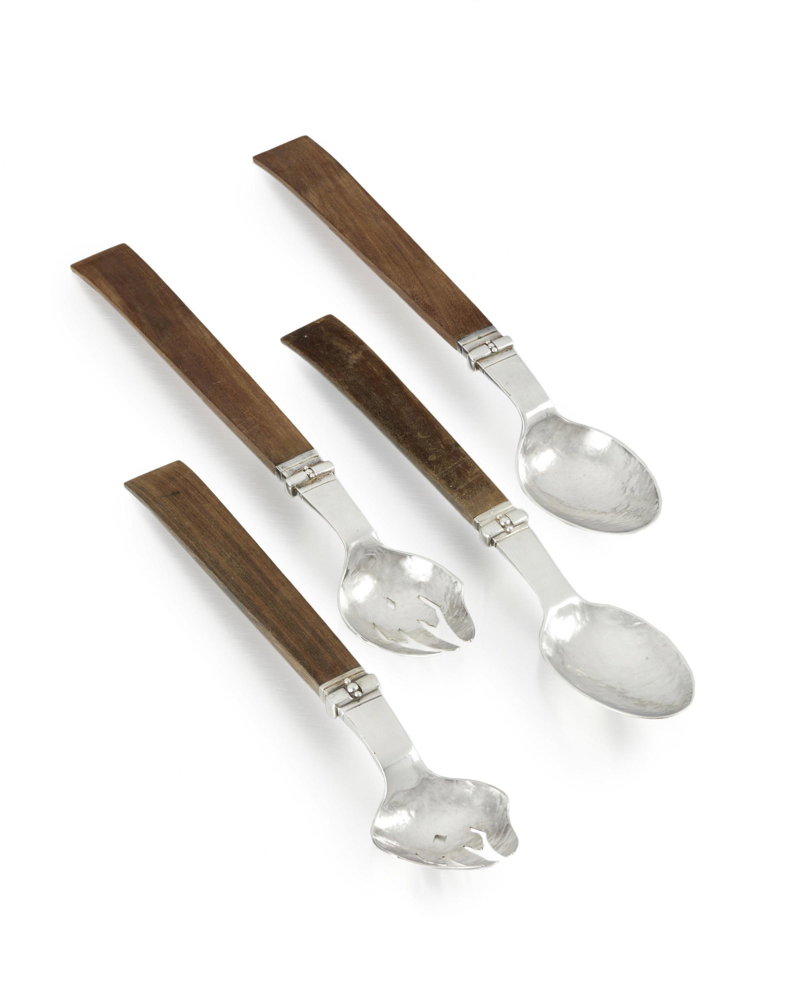 Two sets of William Spratling rosewood and silver salad: 1933-1938 and 1940-1944; First Design Period; Taxco, Mexico Each stamped for William Spratling; One stamped: Spratling Silver Comprising two sets each with a widening rosewood handle, 4 pieces Longest