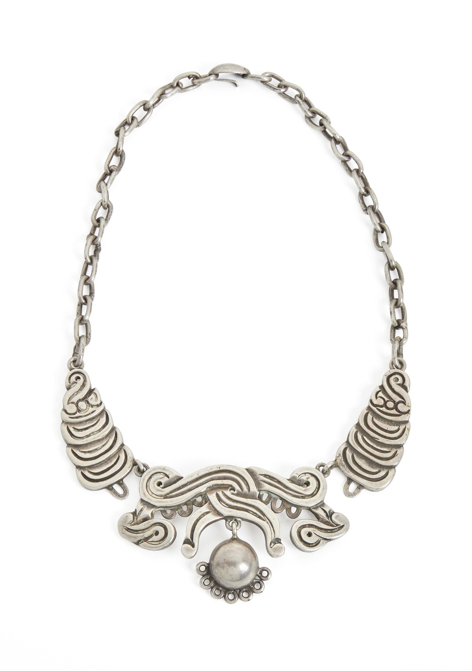 A William Spratling silver necklace: 1940-1944; First Design Period; Taxco, Mexico Stamped for William Spratling; Further stamped: Made in Mexico / Silver Designed with three molded silver sections suspending a half sphere 15.25" L x 1.6