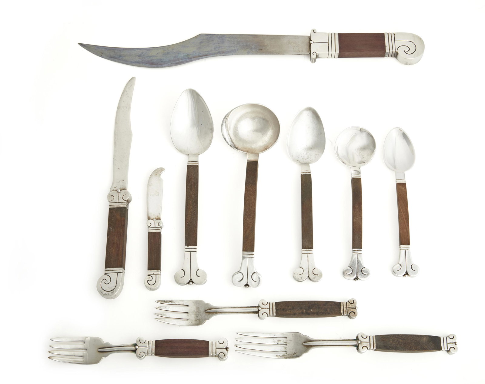A Hector Aguilar rosewood and silver "Aztec" flatware: 1940-1962; Taxco, Mexico Each stamped for Hector Aguilar; Various further stamps: Taxco / 940 / Made in Mexico / Sterling / Eagle 9 Each with rosewood handle designed with a curled terminal and ball t