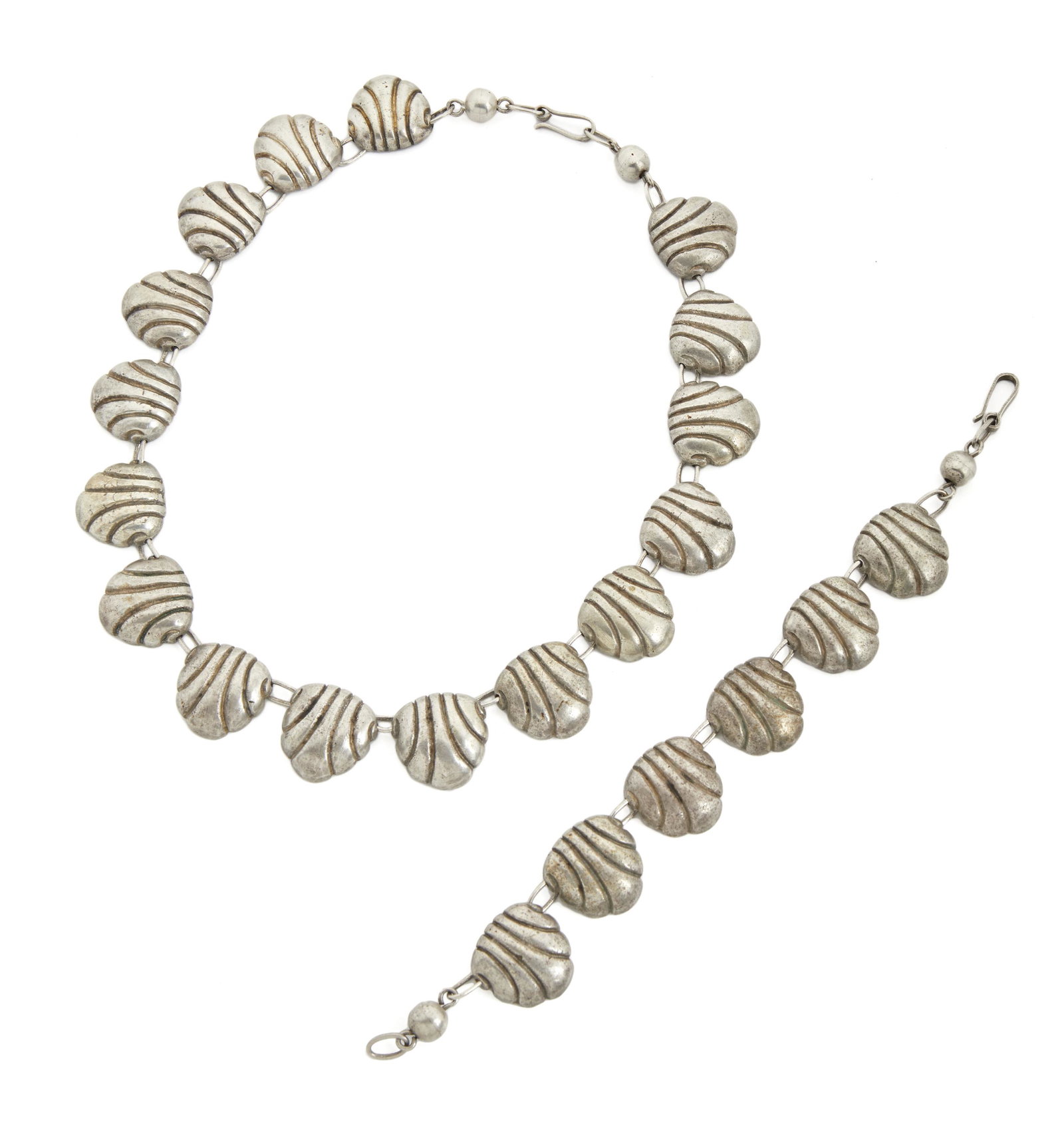 A set of William Spratling silver jewelry: 1940-1944; First Design Period; Taxco, Mexico Each stamped for William Spratling; Further stamped: Made in Mexico / Silver Each designed with shell links, comprising a necklace (17.5" L x .875" H), an