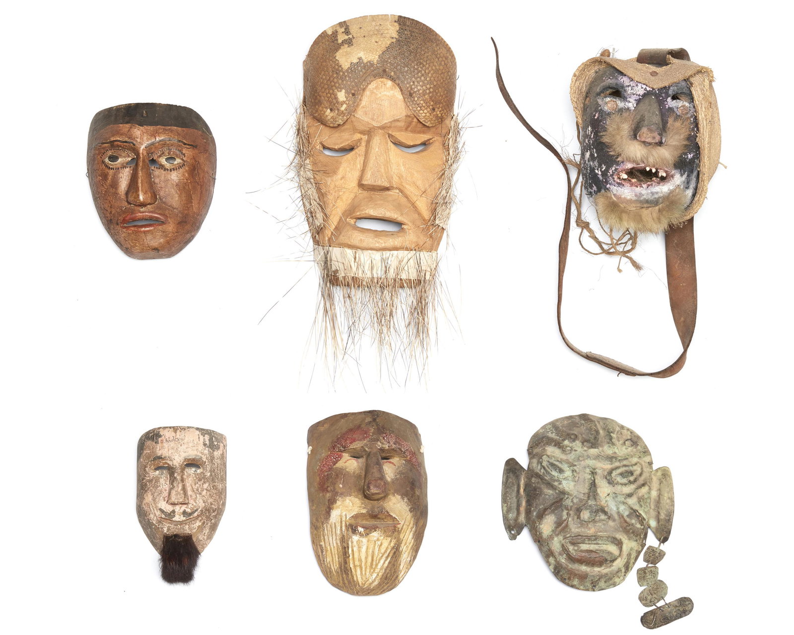 Six Mexican festival masks: 20th Century; Mexico Comprising five polychromed carved wood figural masks with applied hair, straw, armadillo shell, and animal tooth decorations and one hammered metal figural mask with an earring, 
