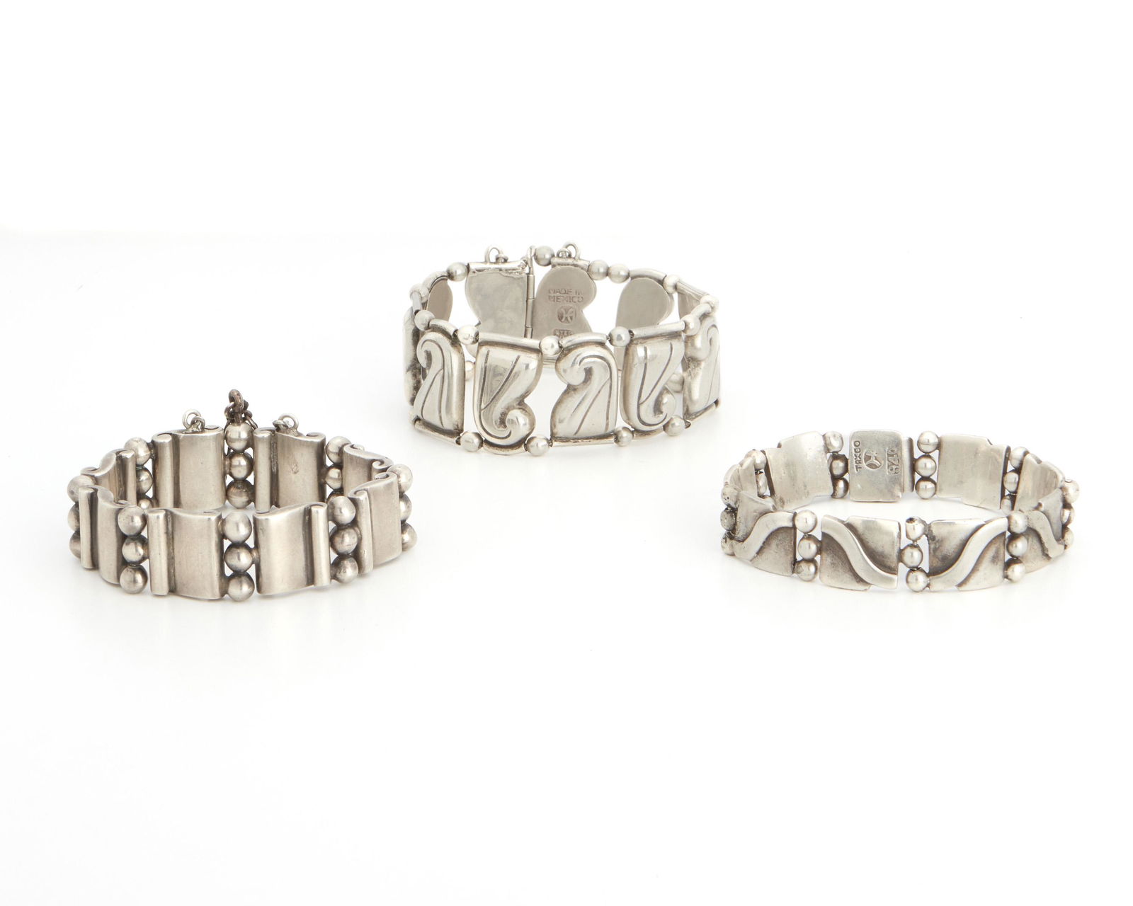 Three Hector Aguilar silver link bracelets: 1940-1945; Taxco, Mexico Each stamped for Hector Aguilar; One stamped: Made in Mexico, Sterling; Two stamped: Taxco / 940 Comprising a .940 silver "S"-motif link bracelet (7" L x .625" H), a sterlin